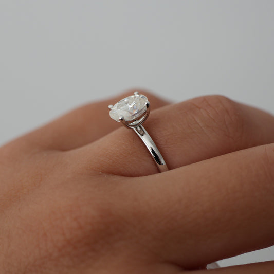 Side view of a 1.5 carat oval solitaire moissanite engagement ring in silver