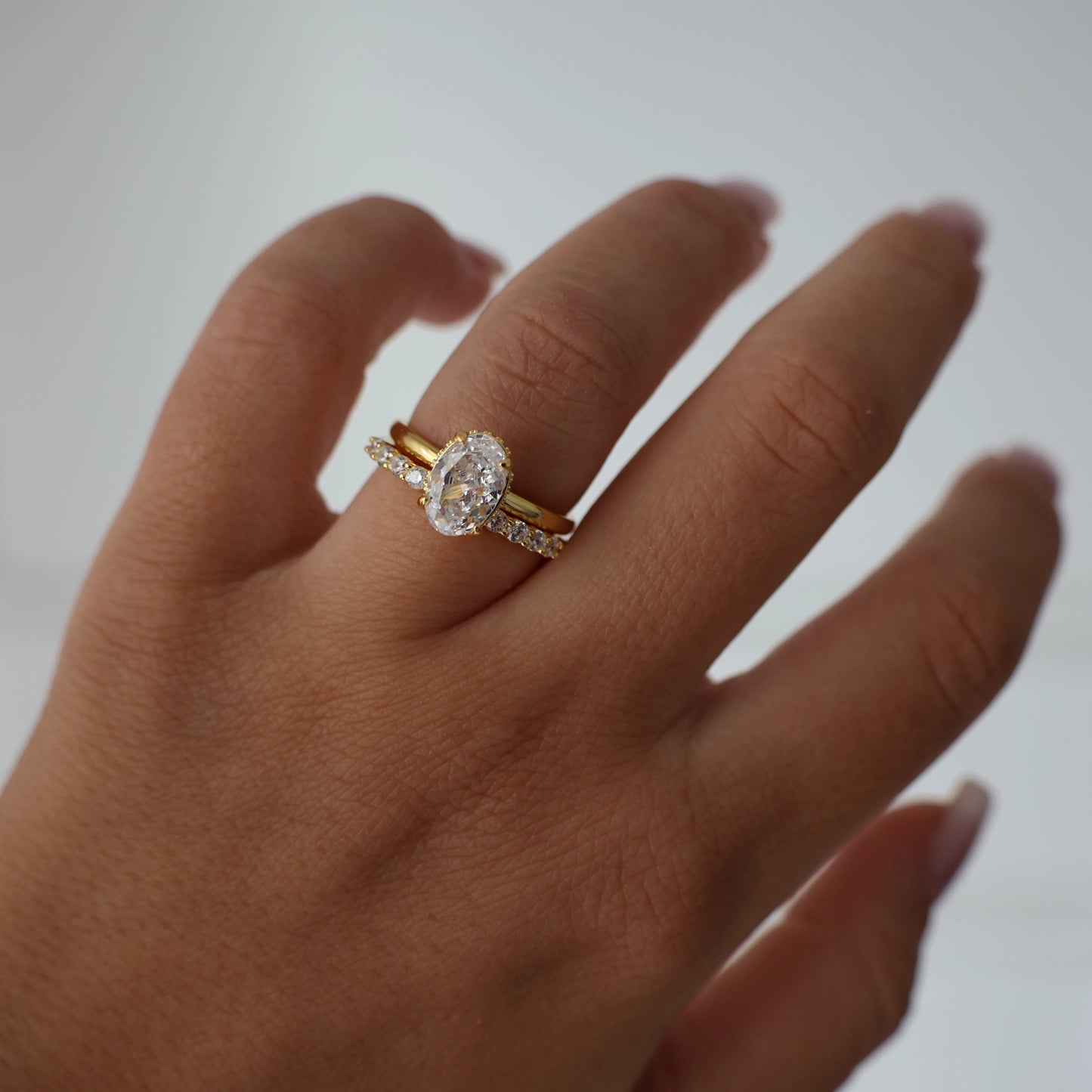 1.5 carat oval ring with hidden halo in gold stacked with eternity band