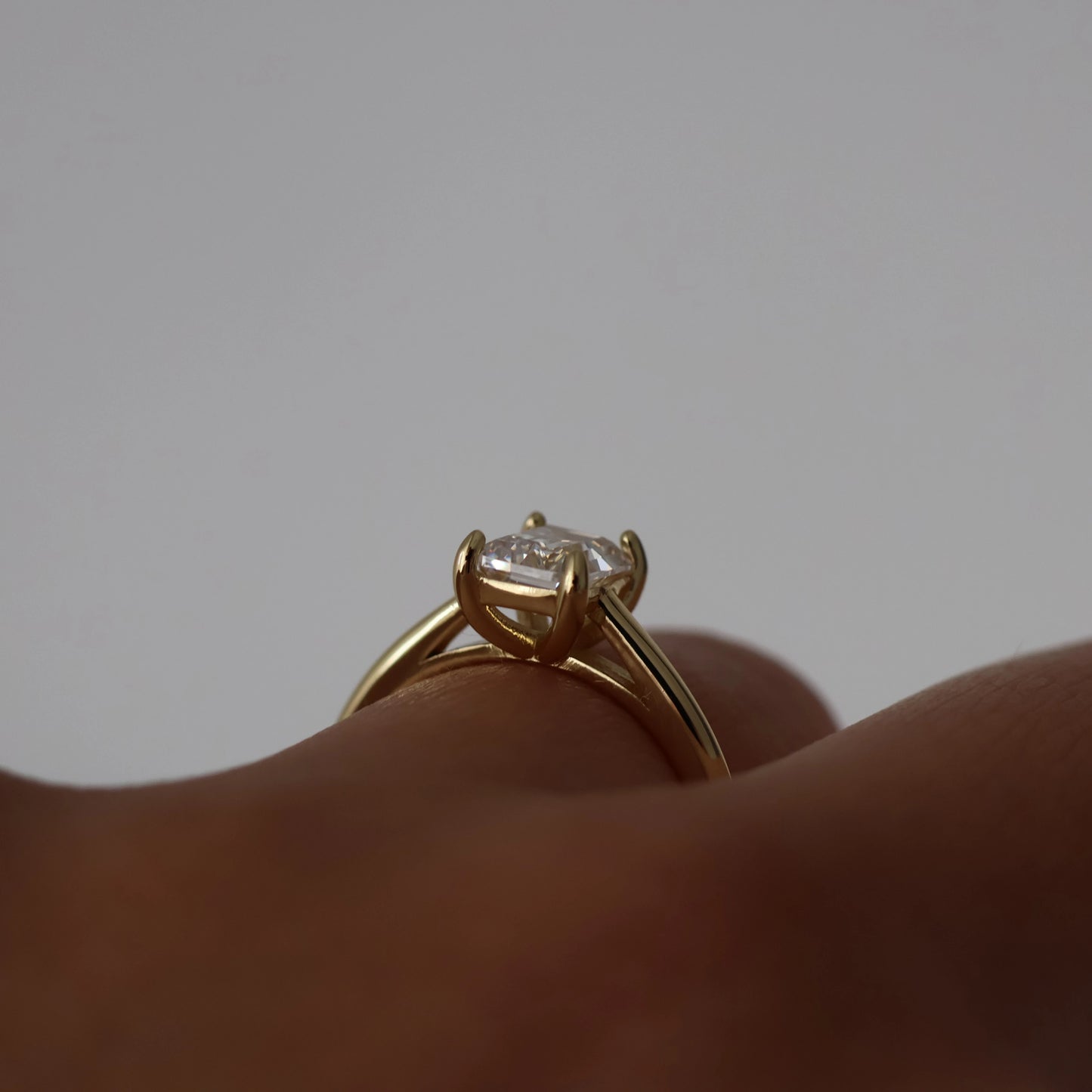 Side view of 1 carat emerald cut cubic zirconia solitaire gold ring