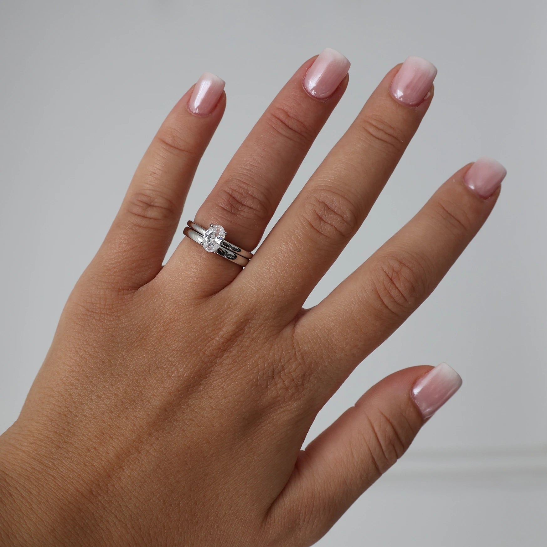 1 carat oval cut cubic zirconia engagement ring styled with a matching silver wedding band