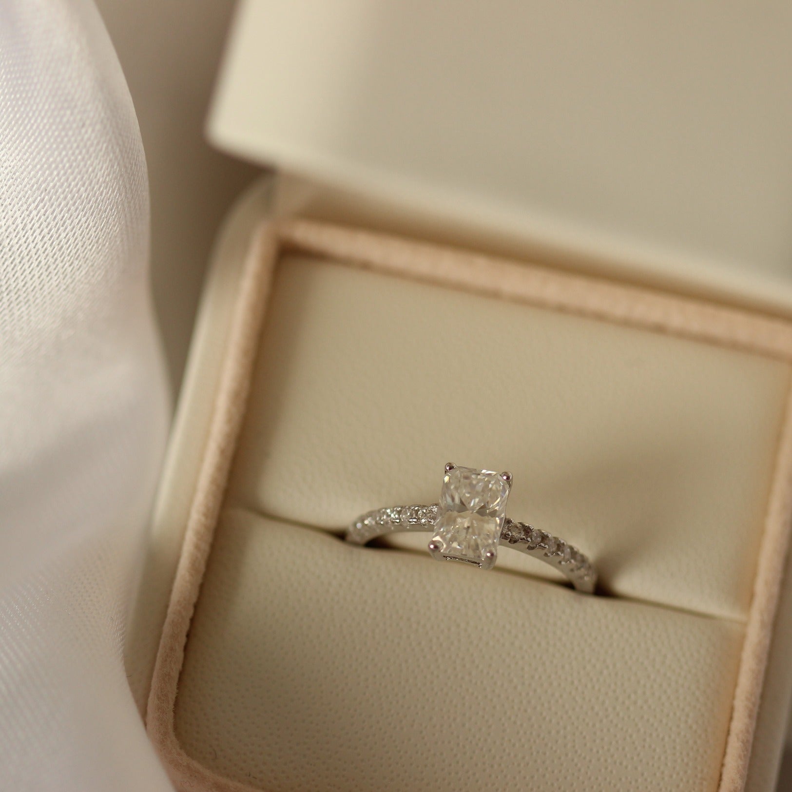 1 carat radiant cut moissanite ring with a pavé band in proposal ring box
