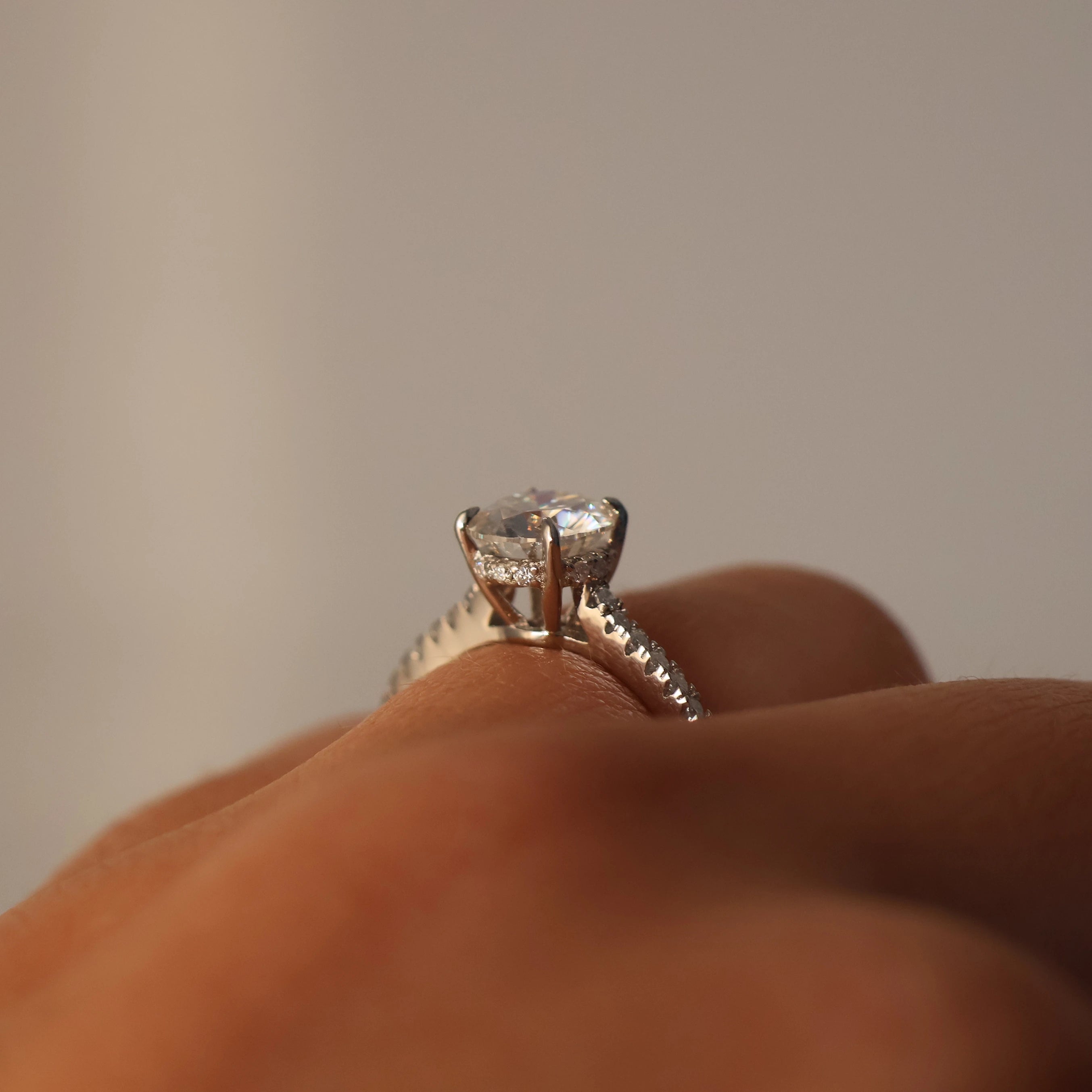 Side view of a 1 carat round moissanite ring with a pavé band