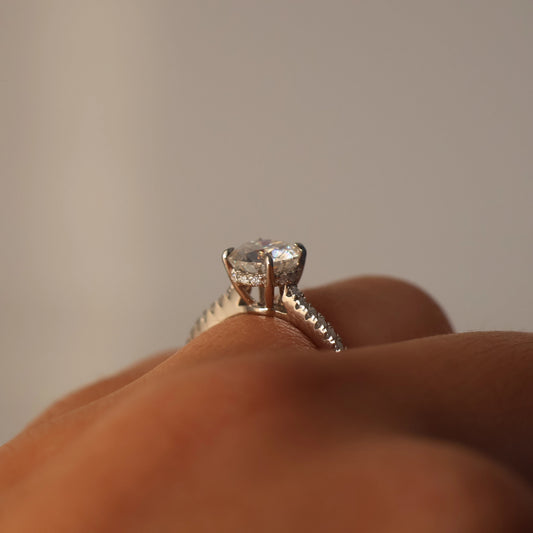 Side view of a 1 carat round moissanite ring with a pavé band