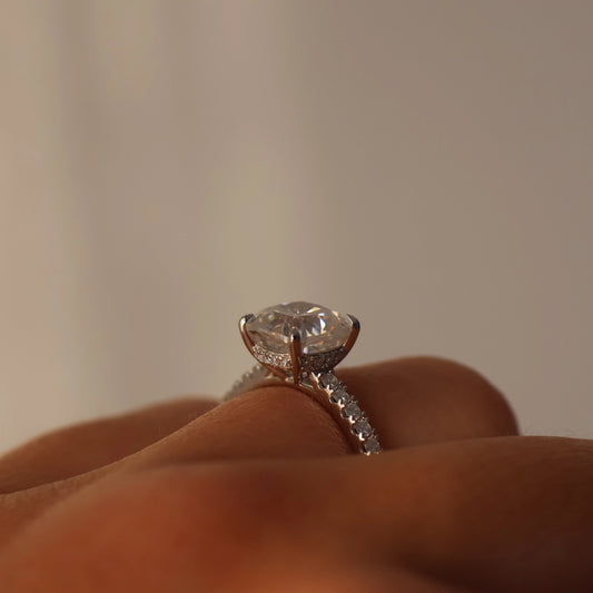 Close up of 2 ct cushion moissanite ring with pave band