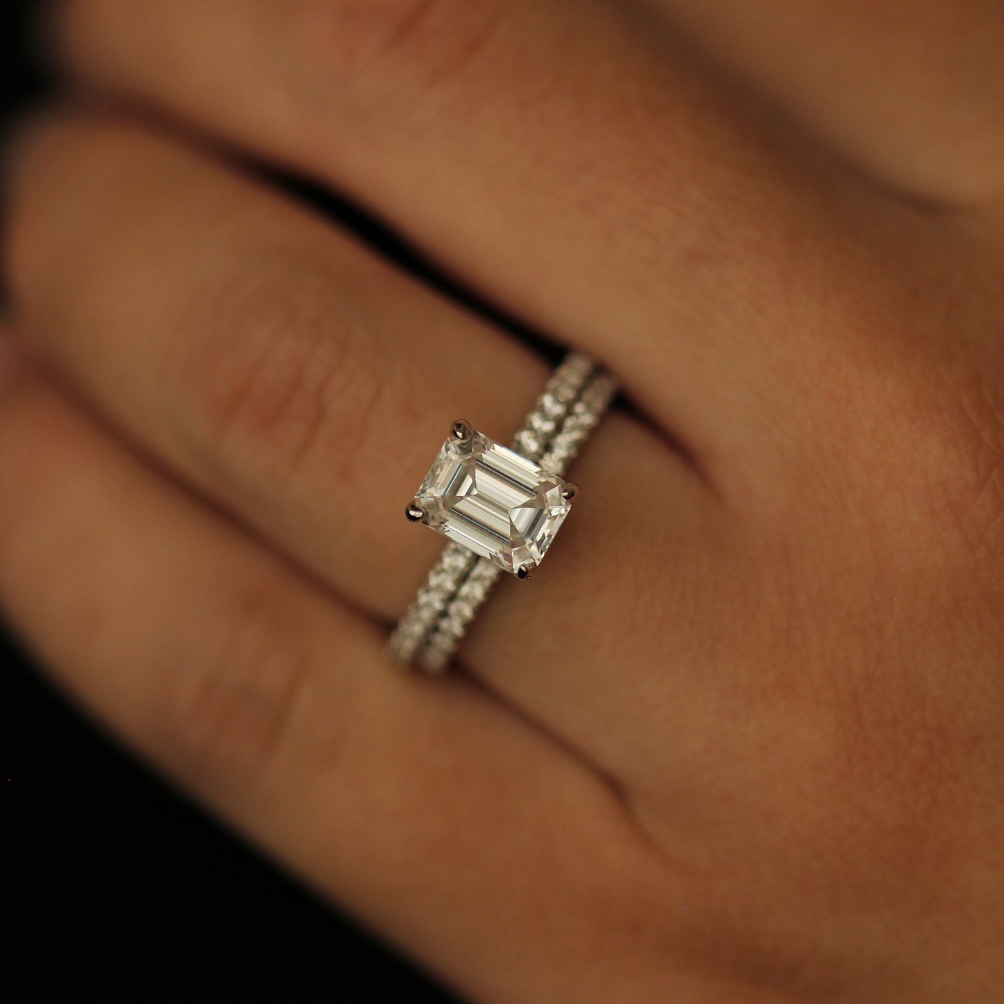Emerald cut moissanite ring on hand stacked with a pavé wedding band