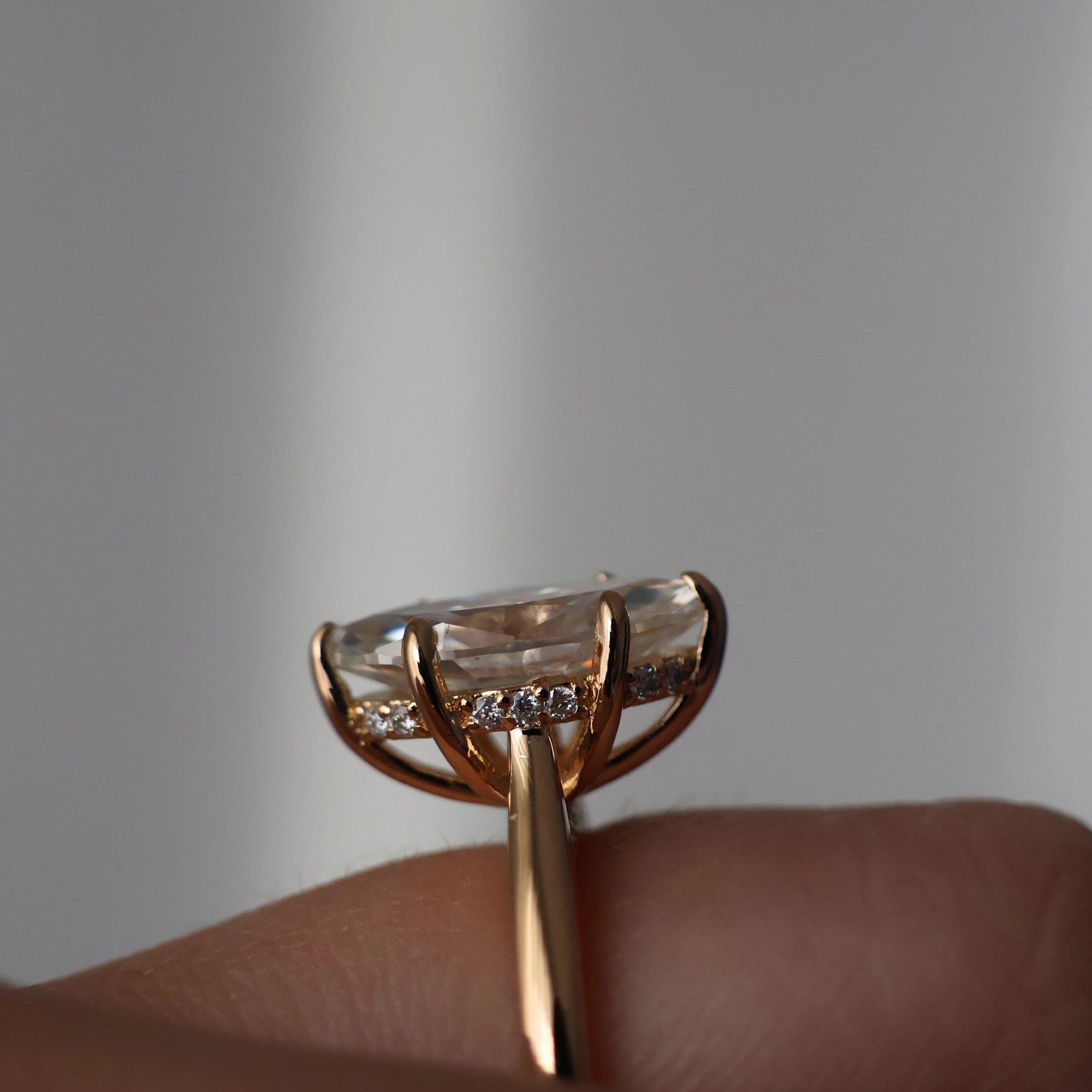 Close up of a 2 ct marquise moissanite ring with hidden halo in 14k gold filled