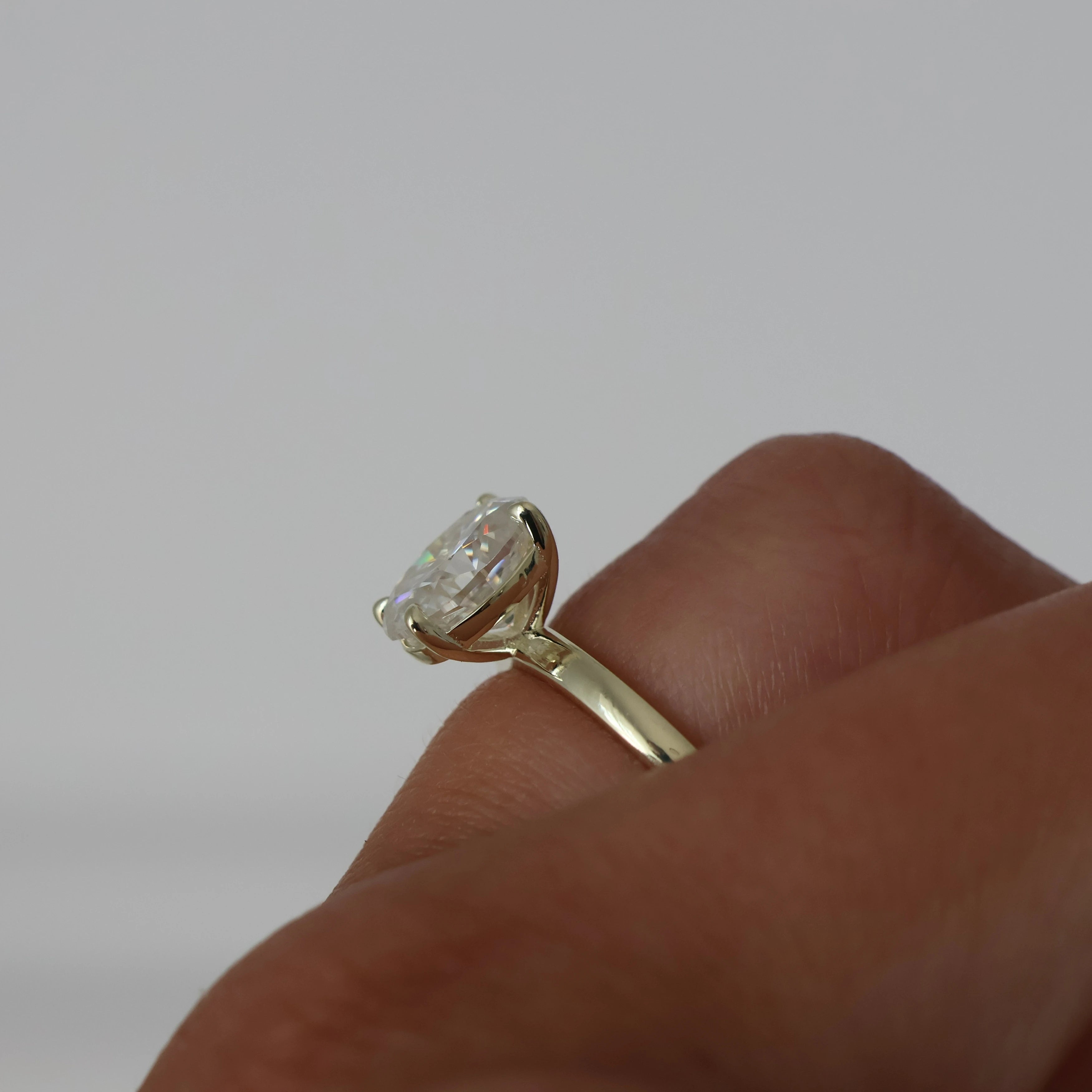 2 carat oval moissanite ring in light 14k gold filled side view