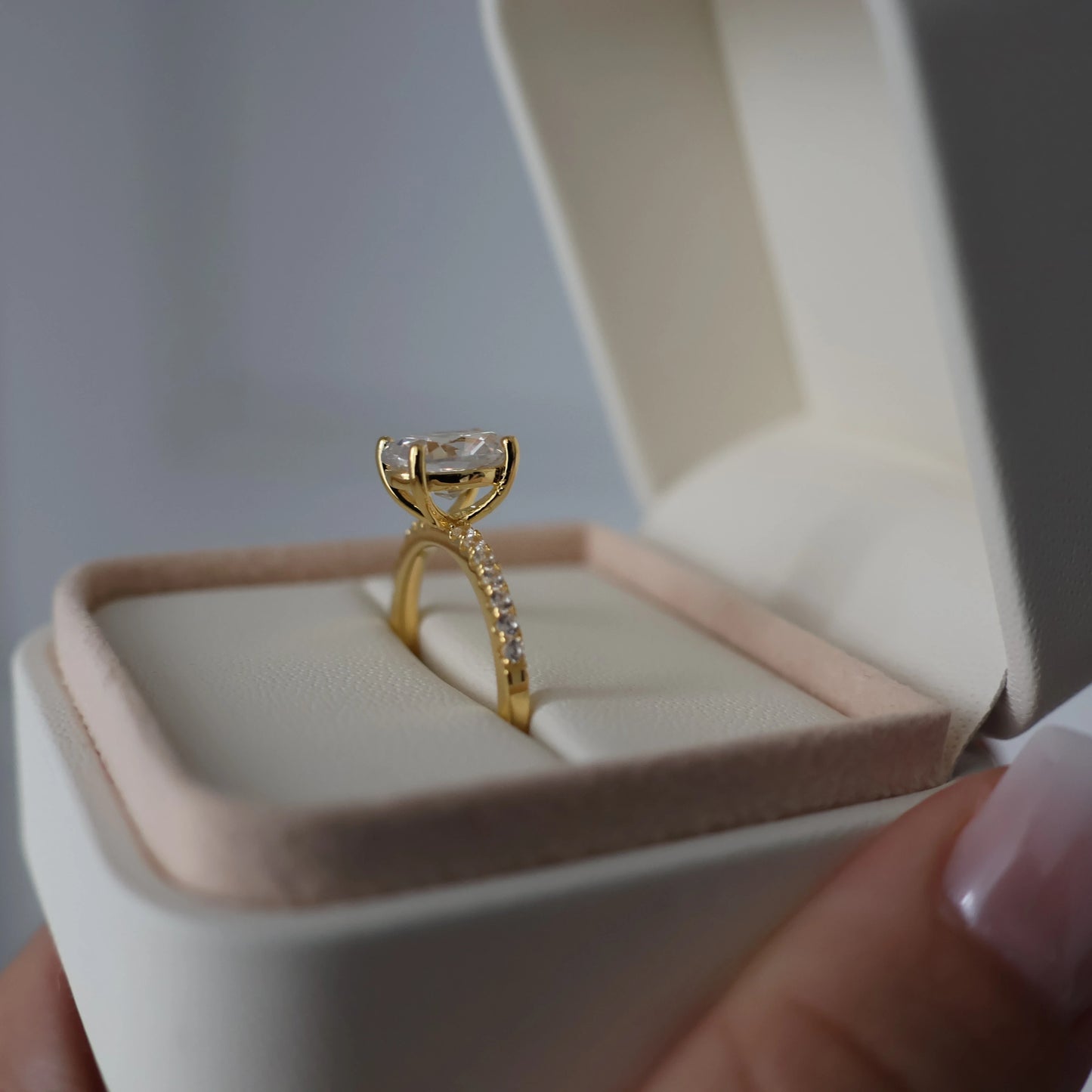 Side view of a 2-carat oval pavé engagement ring with 18K gold plating