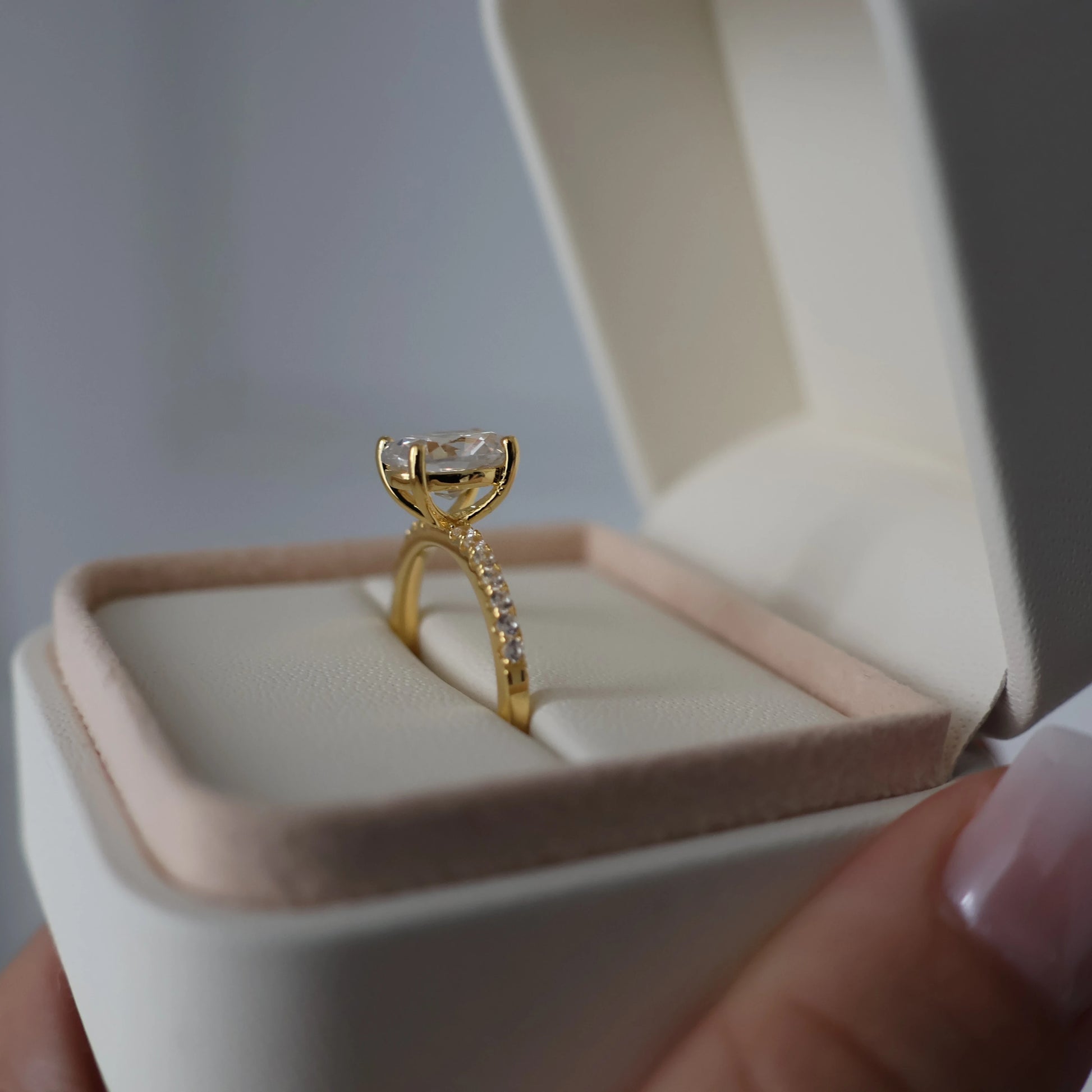 Side view of a 2-carat oval pavé engagement ring with 18K gold plating