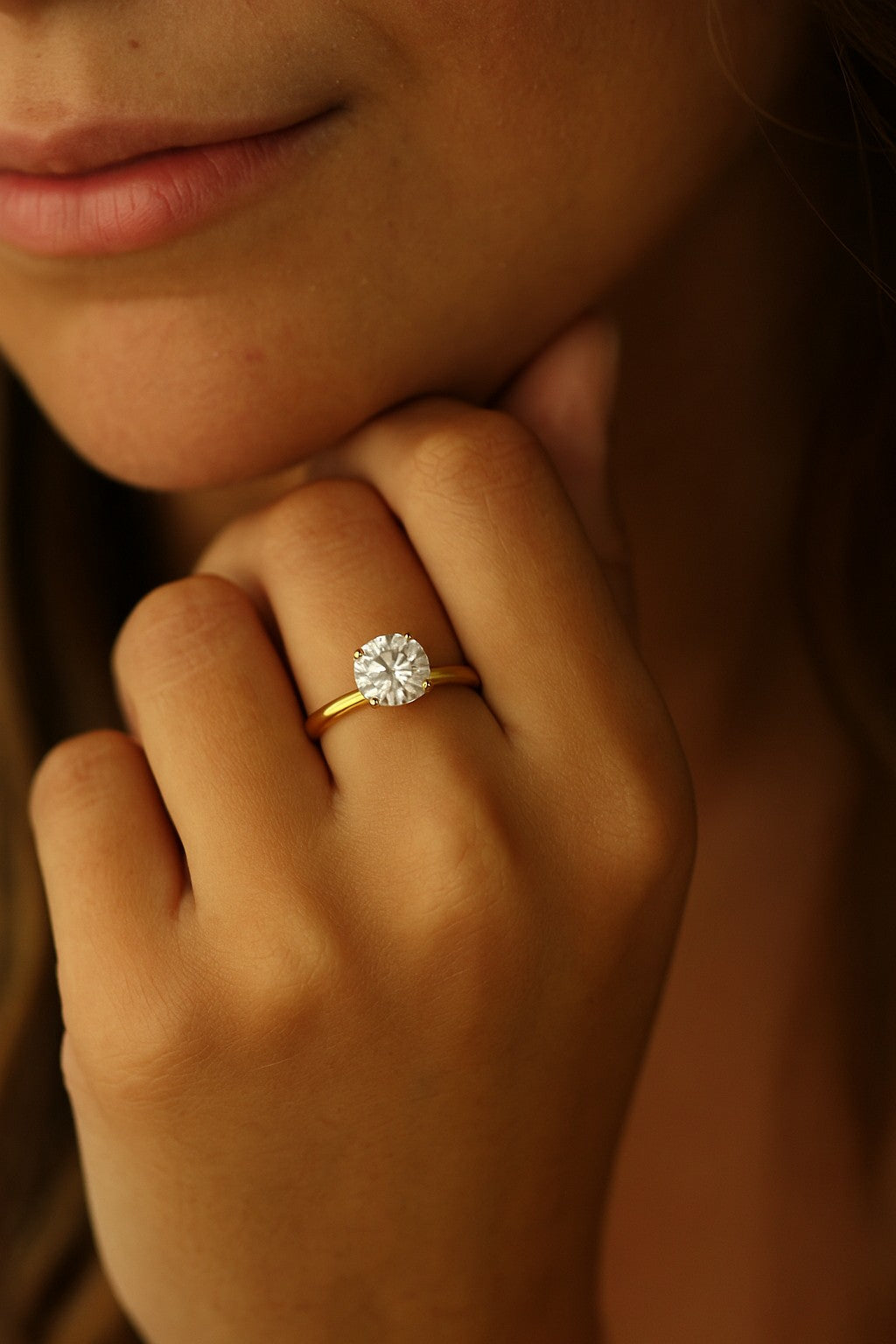 2 carat round cut 14k gold plated ring on model leaning on chin