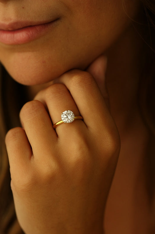 2 carat round cut ring on model leaning on chin