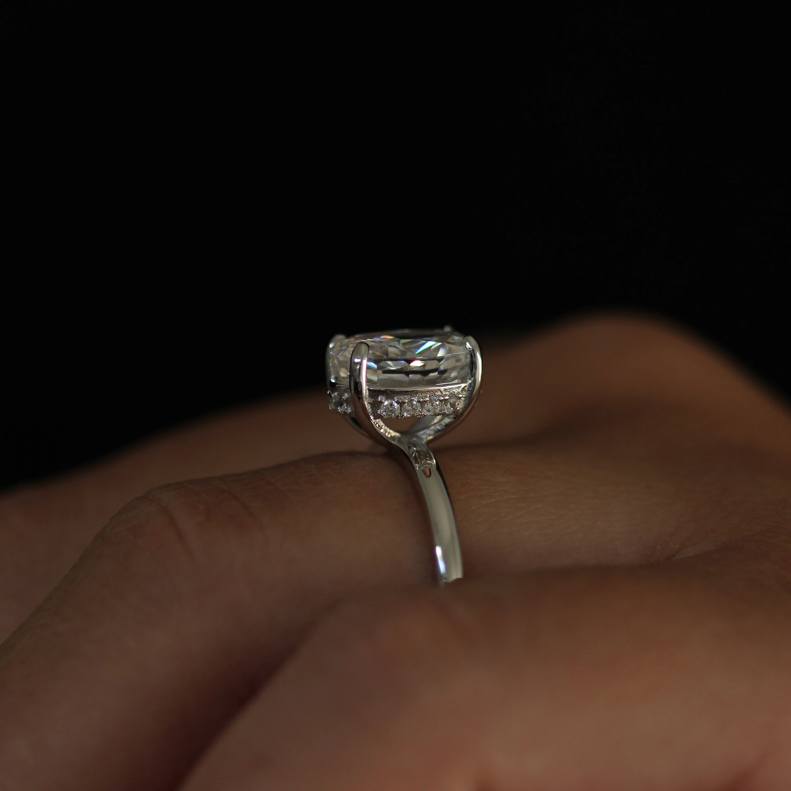 Side profile of 2 carat silver oval ring worn on hand with hidden halo
