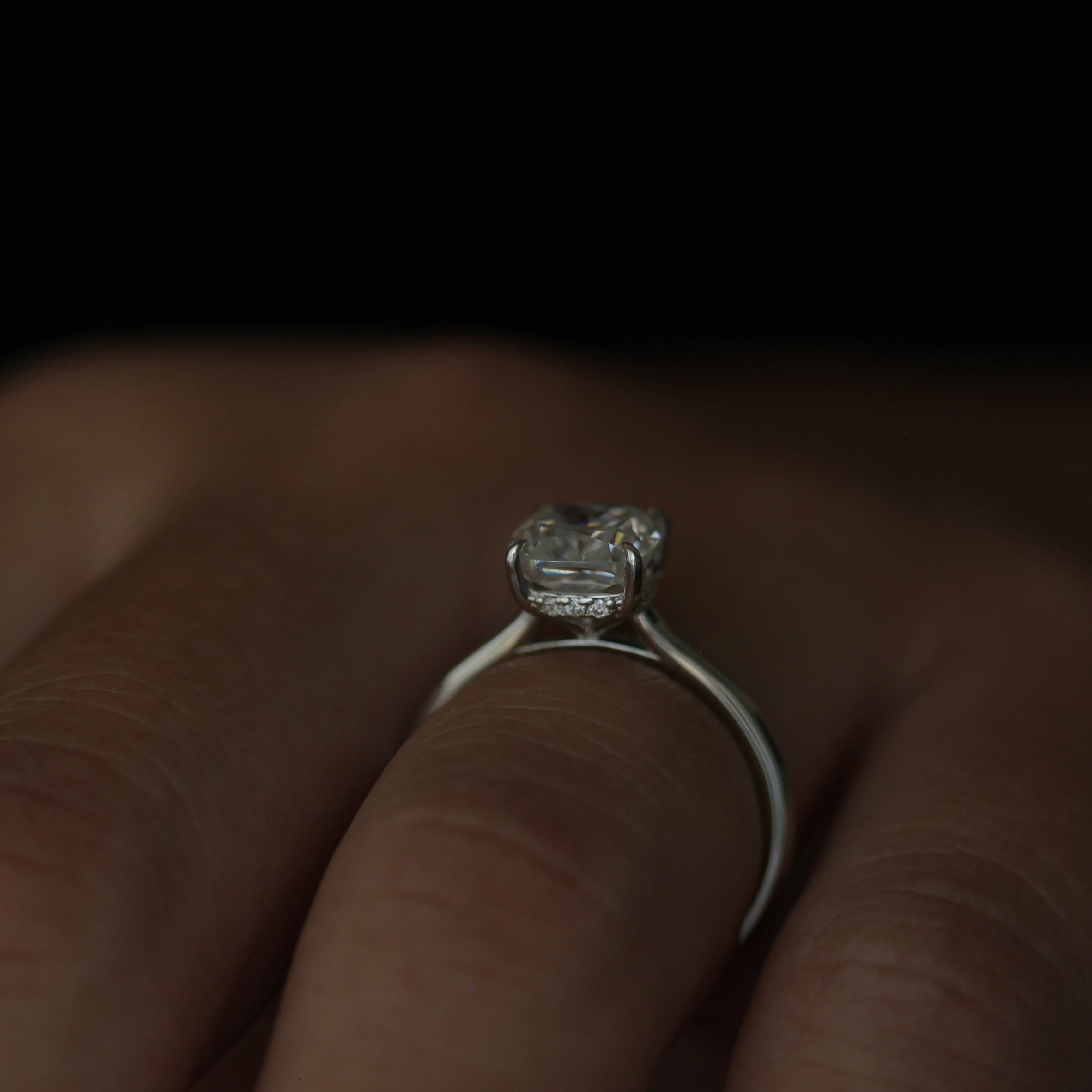 front view of a 2 carat cushion cut moissanite engagement ring set in a silver band