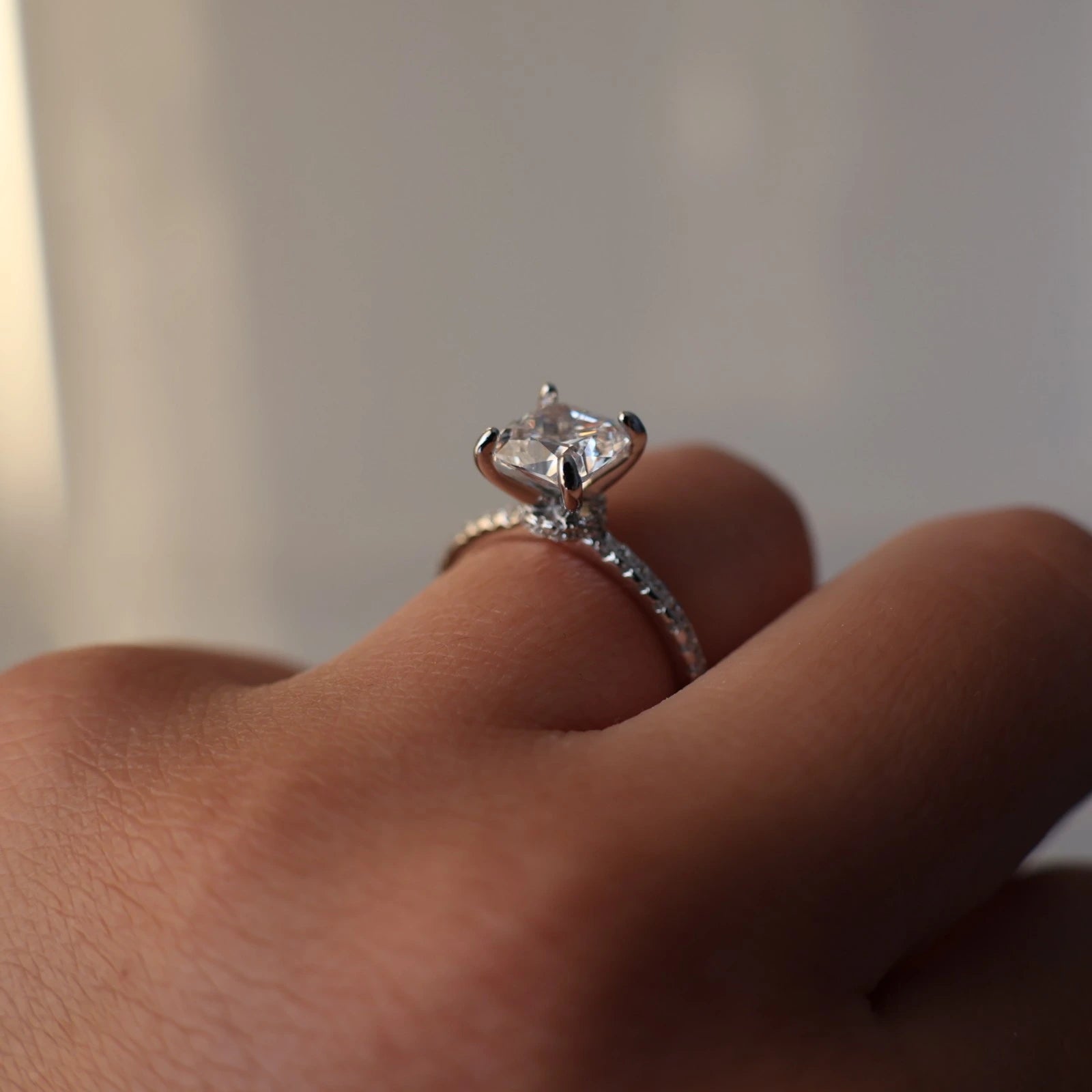 2 carat cushion cut cubic zirconia ring with a silver pavé band and hidden halo