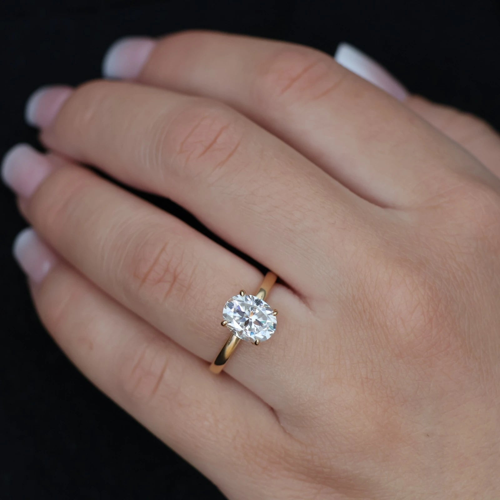 Close up of 2 carat oval moissanite solitaire ring in 14k gold filled