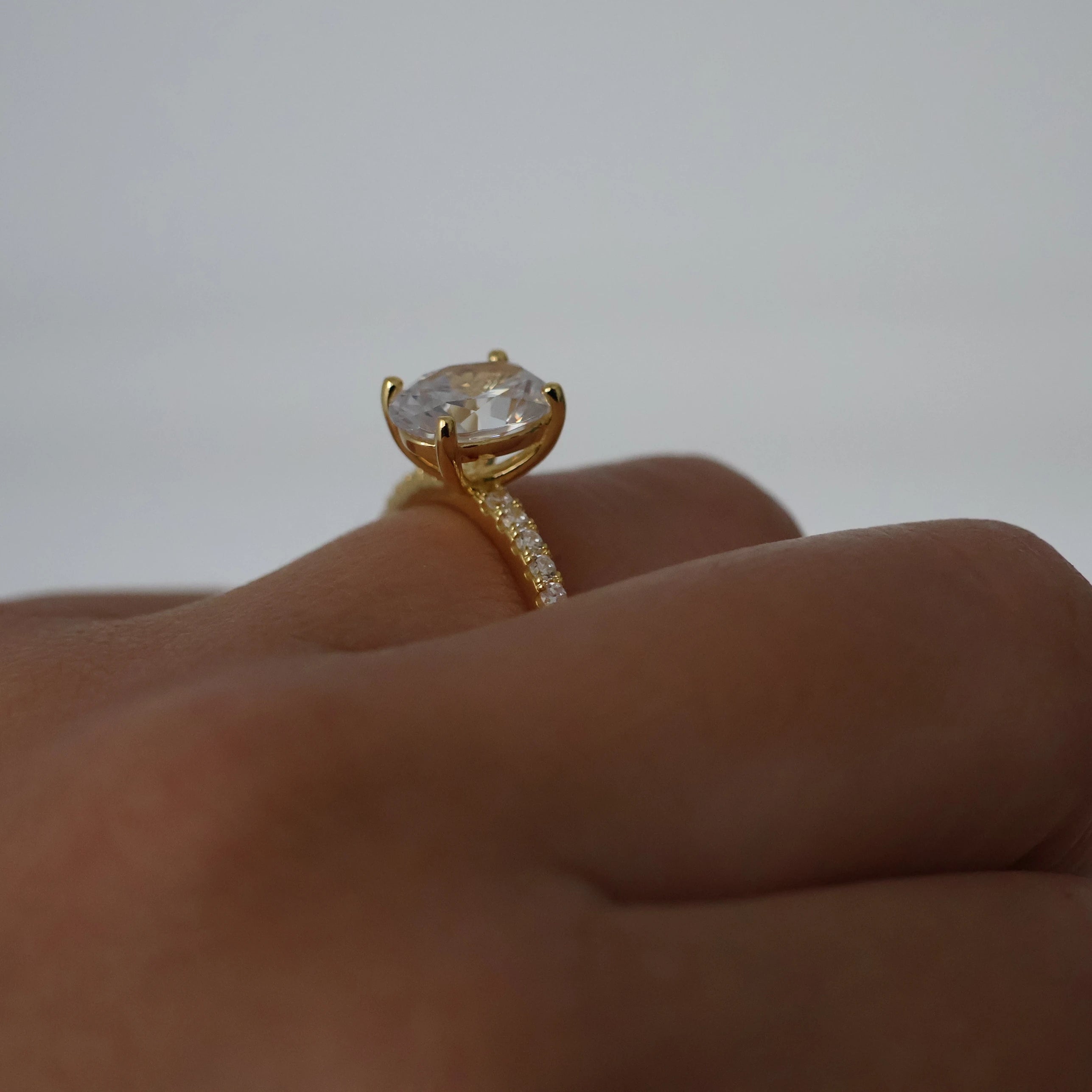 Side view of a 2ct oval pavé ring in 18K gold plating