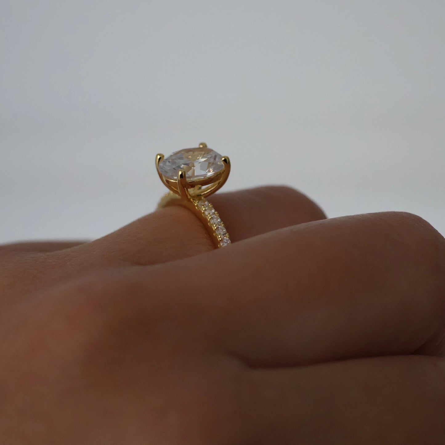 Side view of a 2ct oval pavé ring in 18K gold plating