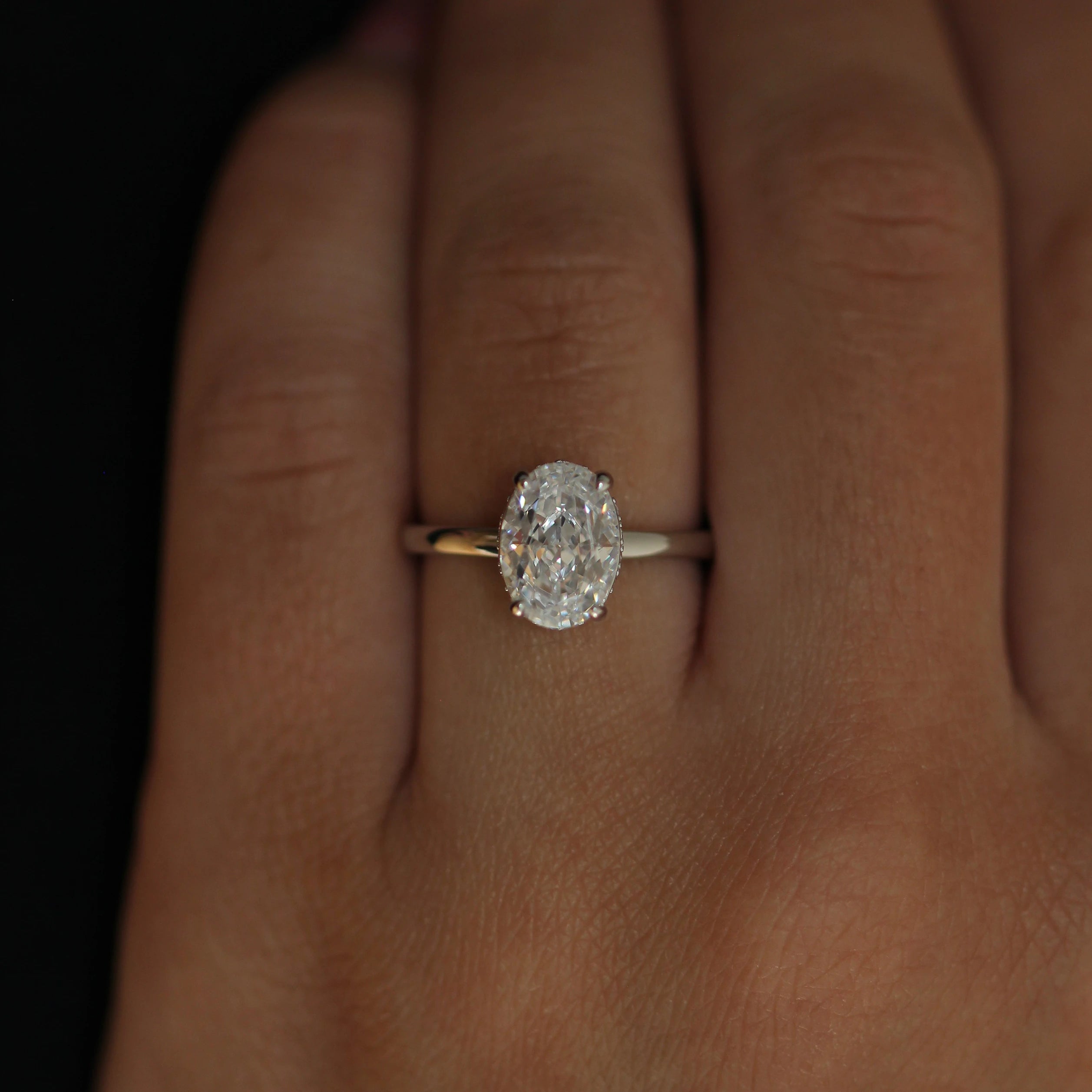 2 carat oval ring in silver worn on hand with hidden halo
