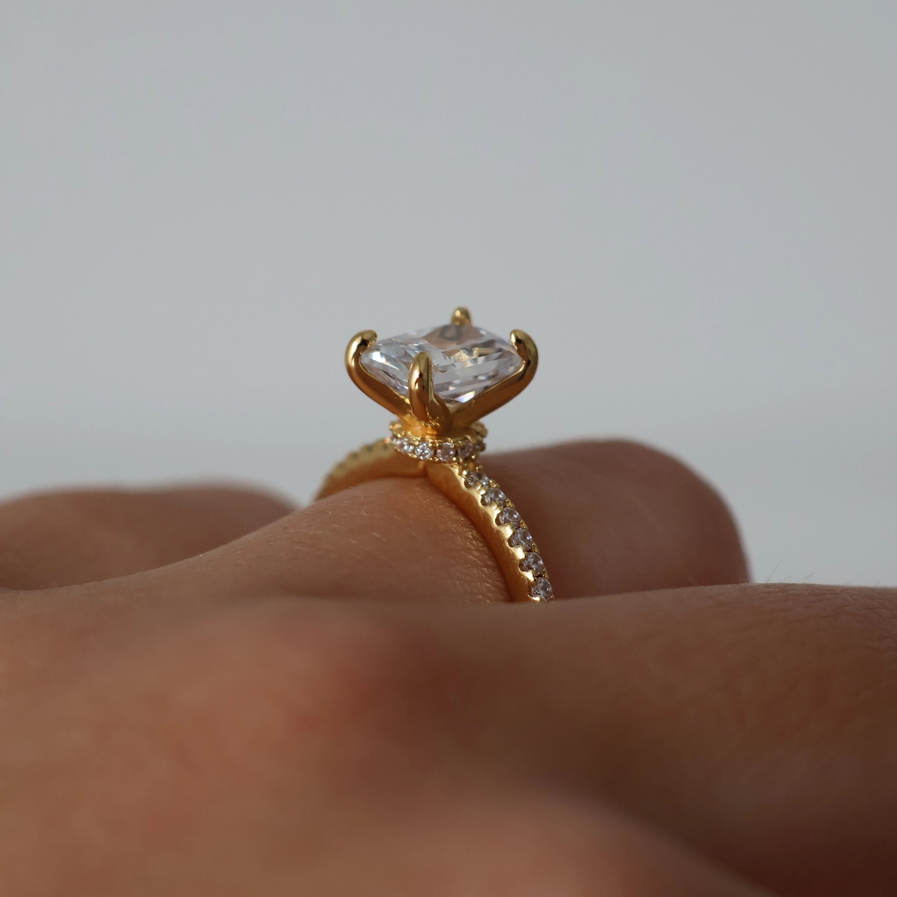 2 carat radiant cut cubic zirconia ring in gold with pavé band and hidden halo