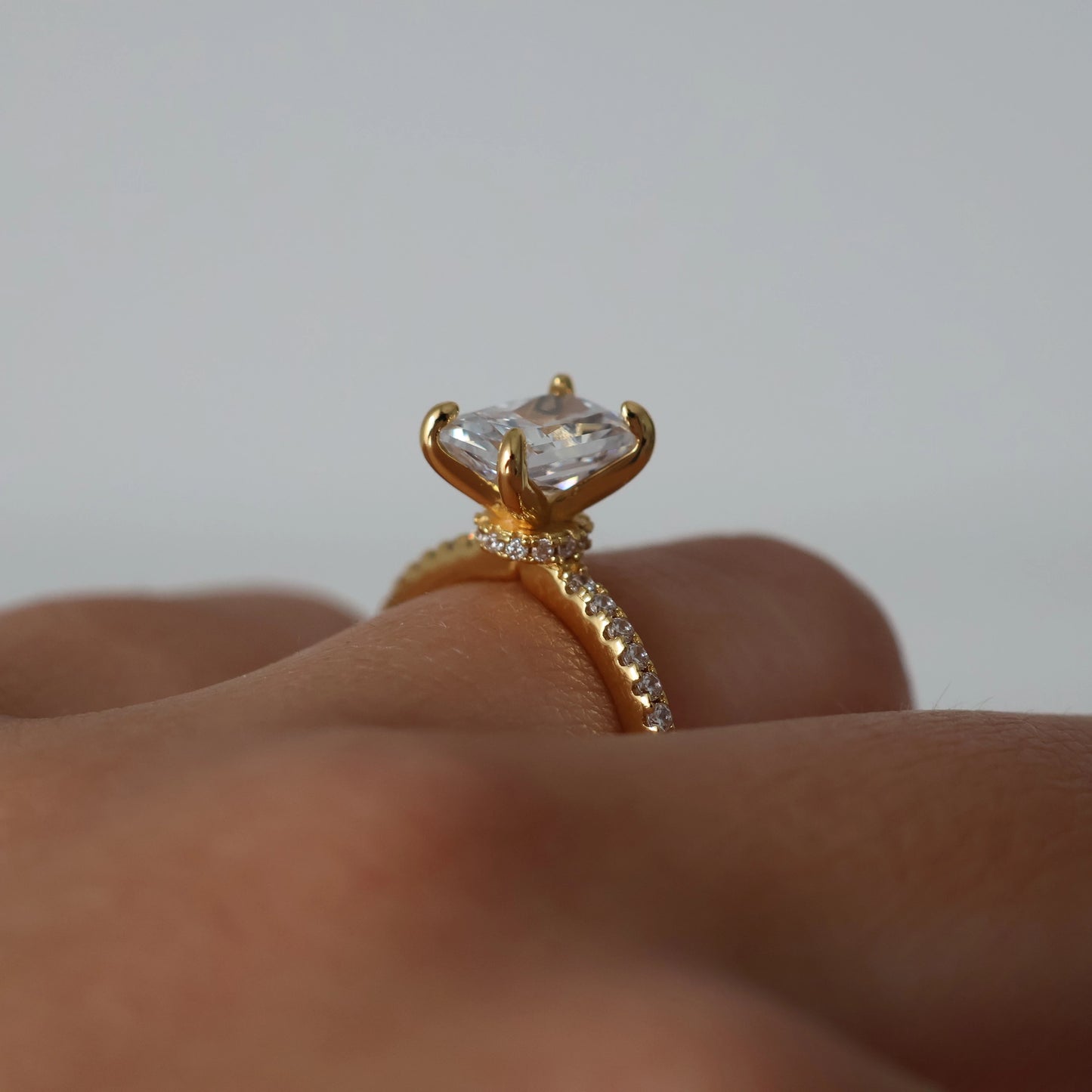 2 carat radiant cut cubic zirconia ring in gold with pavé band and hidden halo