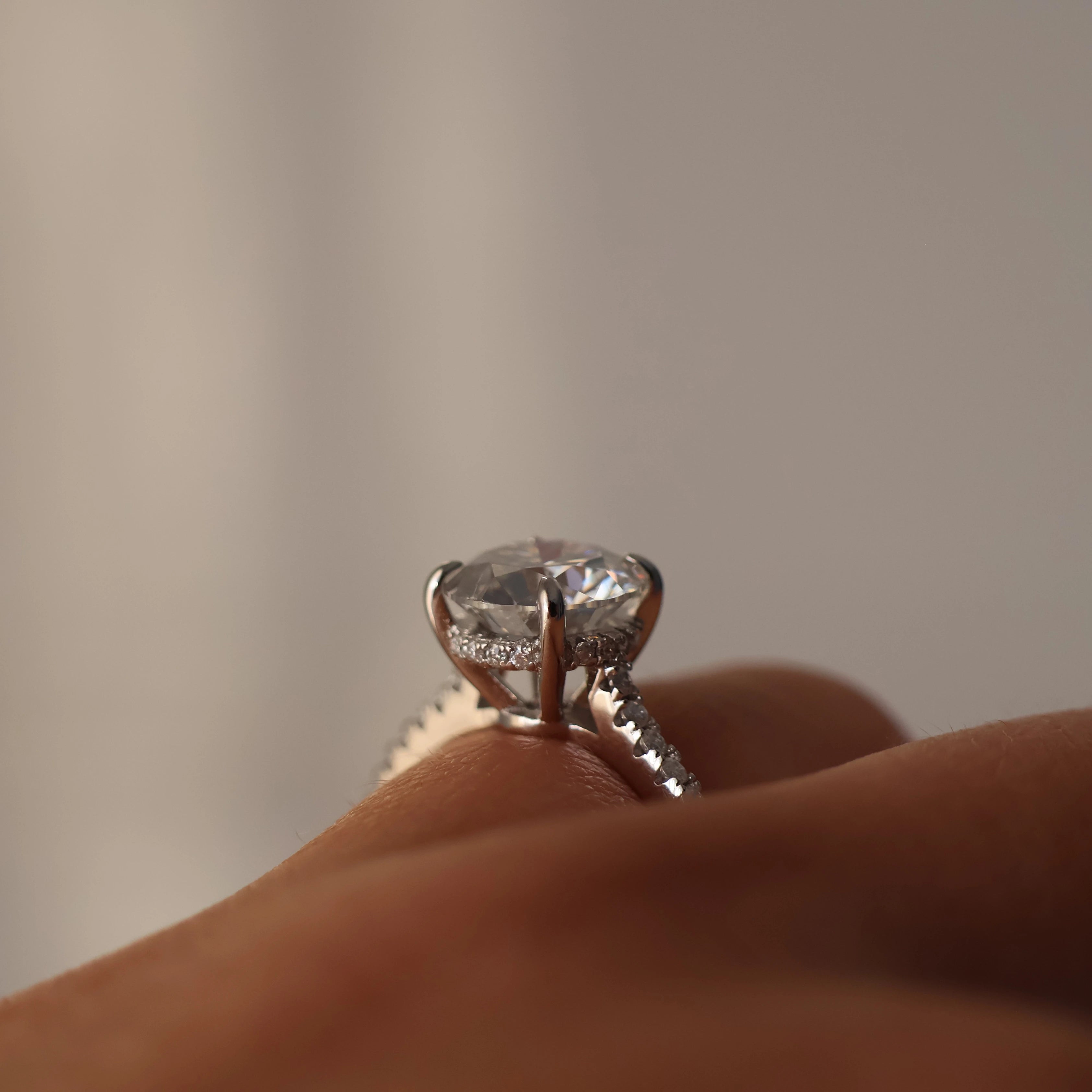 Side view of a 2 carat round moissanite ring with a pavé band