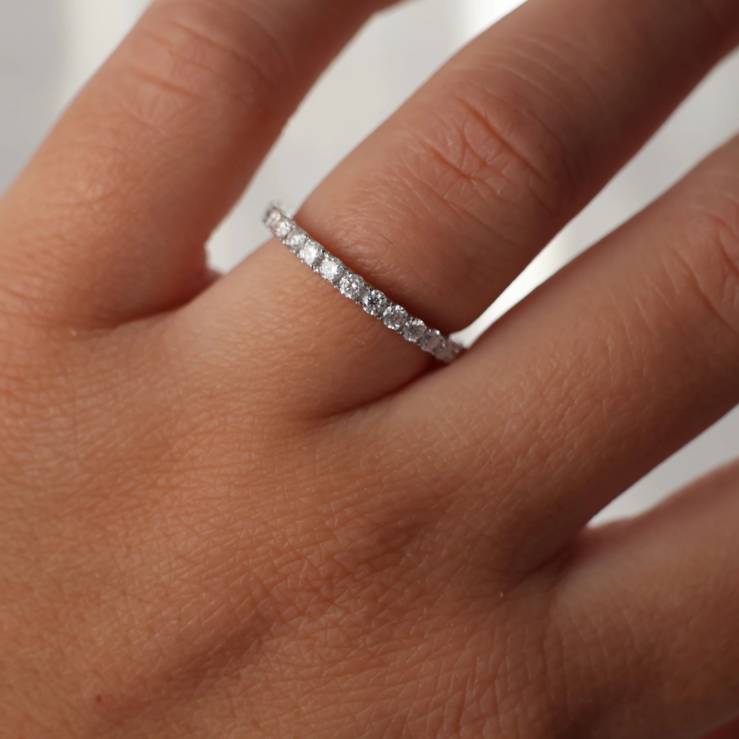 full eternity band featuring round moissanite stones silver
