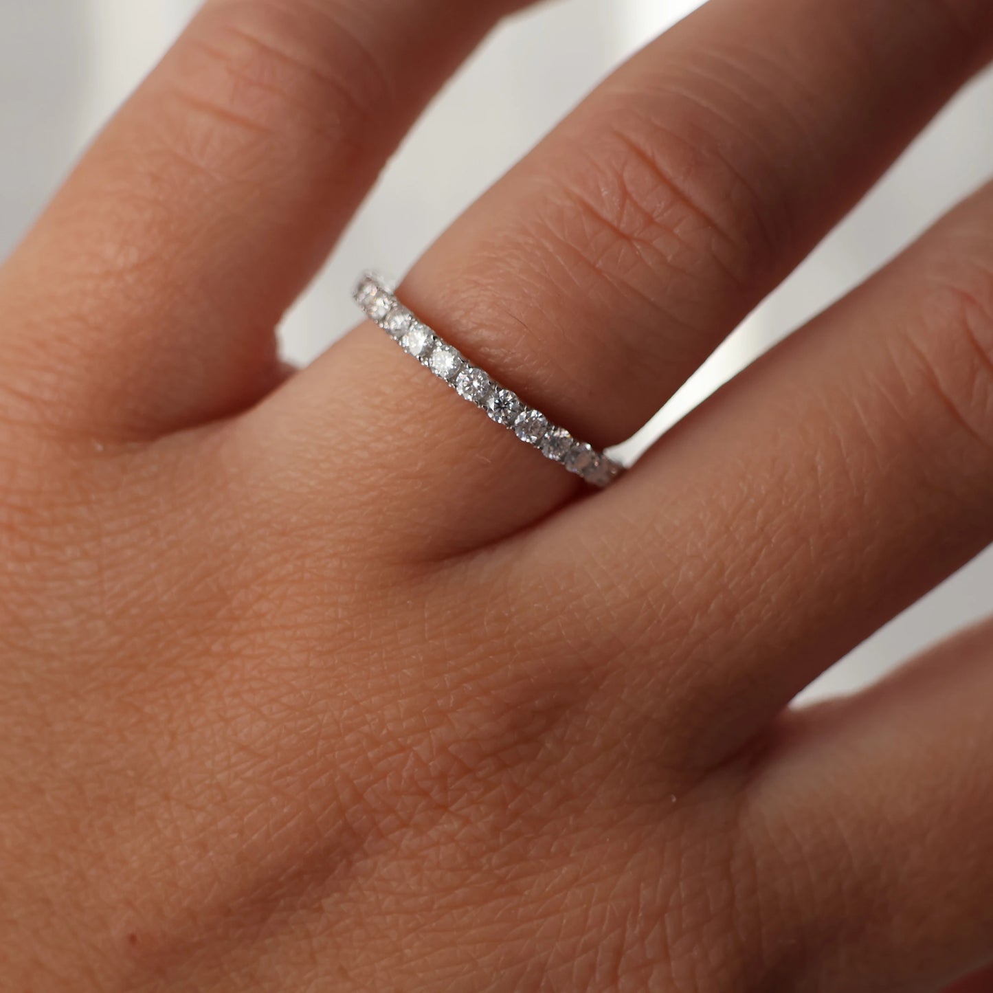 full eternity band featuring round moissanite stones silver