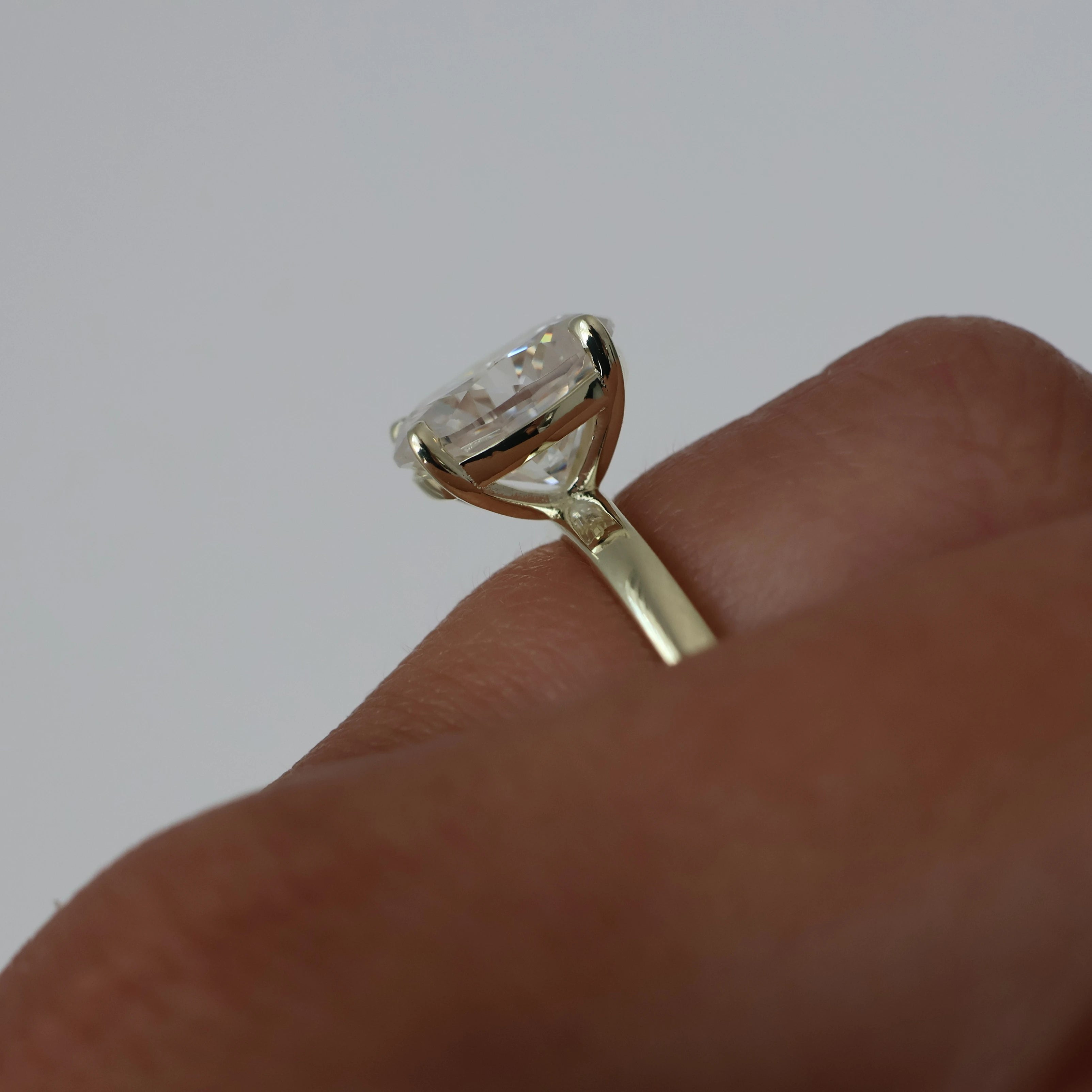 3 carat oval moissanite ring in light 14k gold filled side view