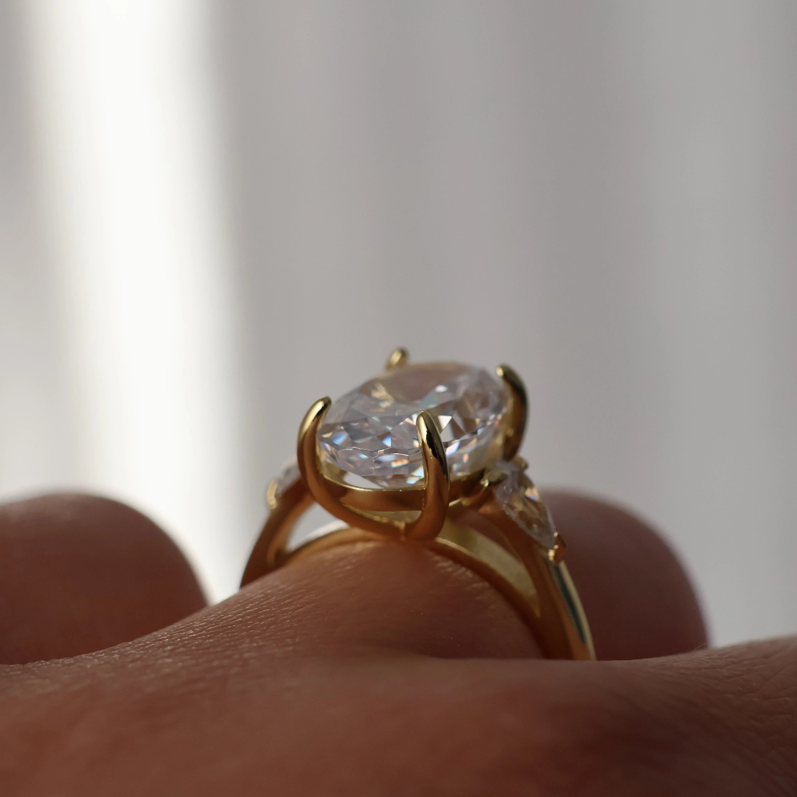 Three stone oval engagement ring with pear cubic zirconia side stones and 14K gold plating