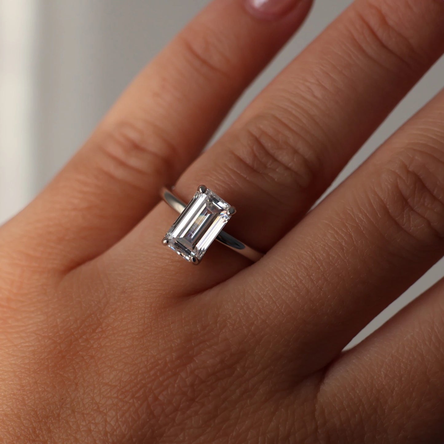close up of 3 carat elongated emerald cut cubic zirconia silver solitaire ring