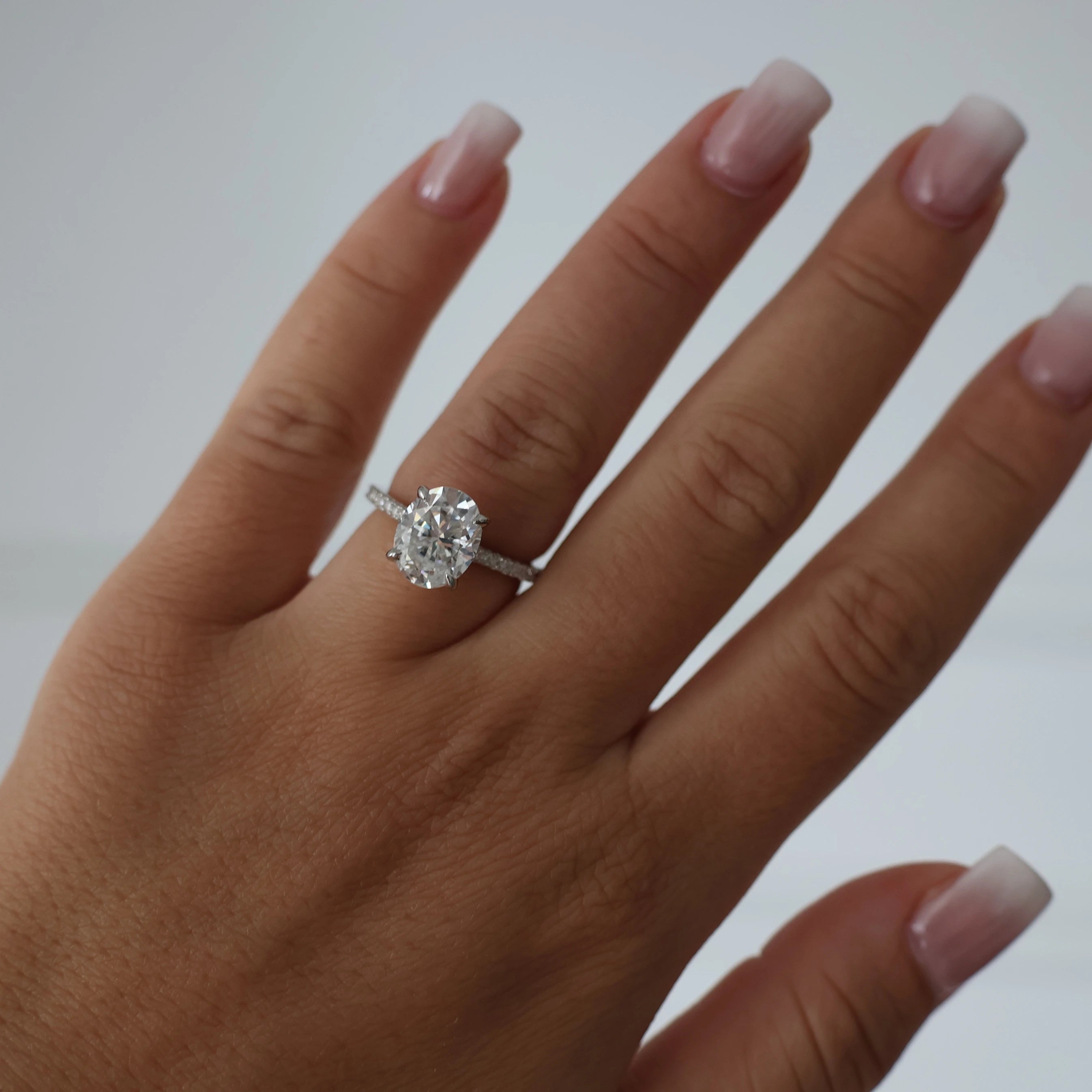 3 carat oval moissanite engagement ring with pave band and hidden halo
