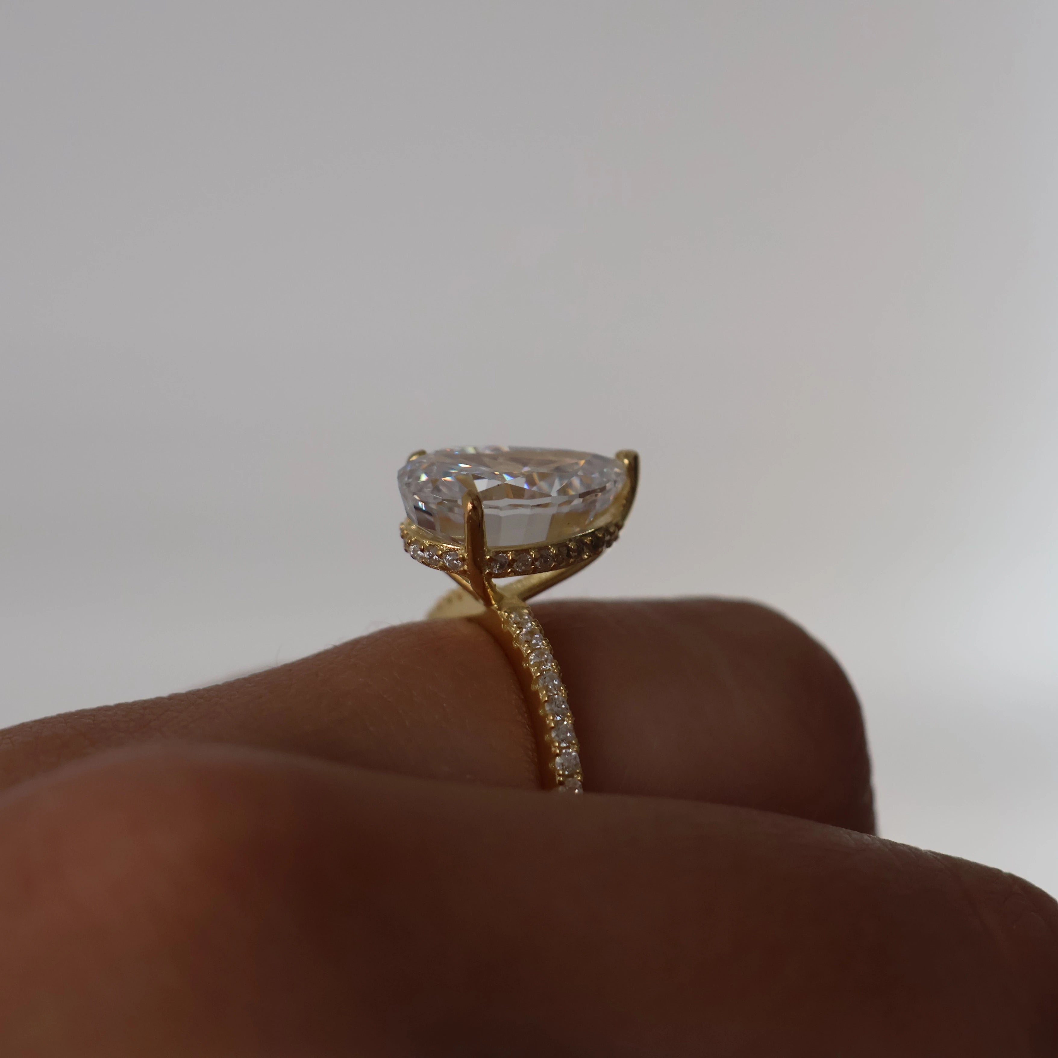 3 carat pear cut cubic zirconia ring in gold with pavé band and hidden halo