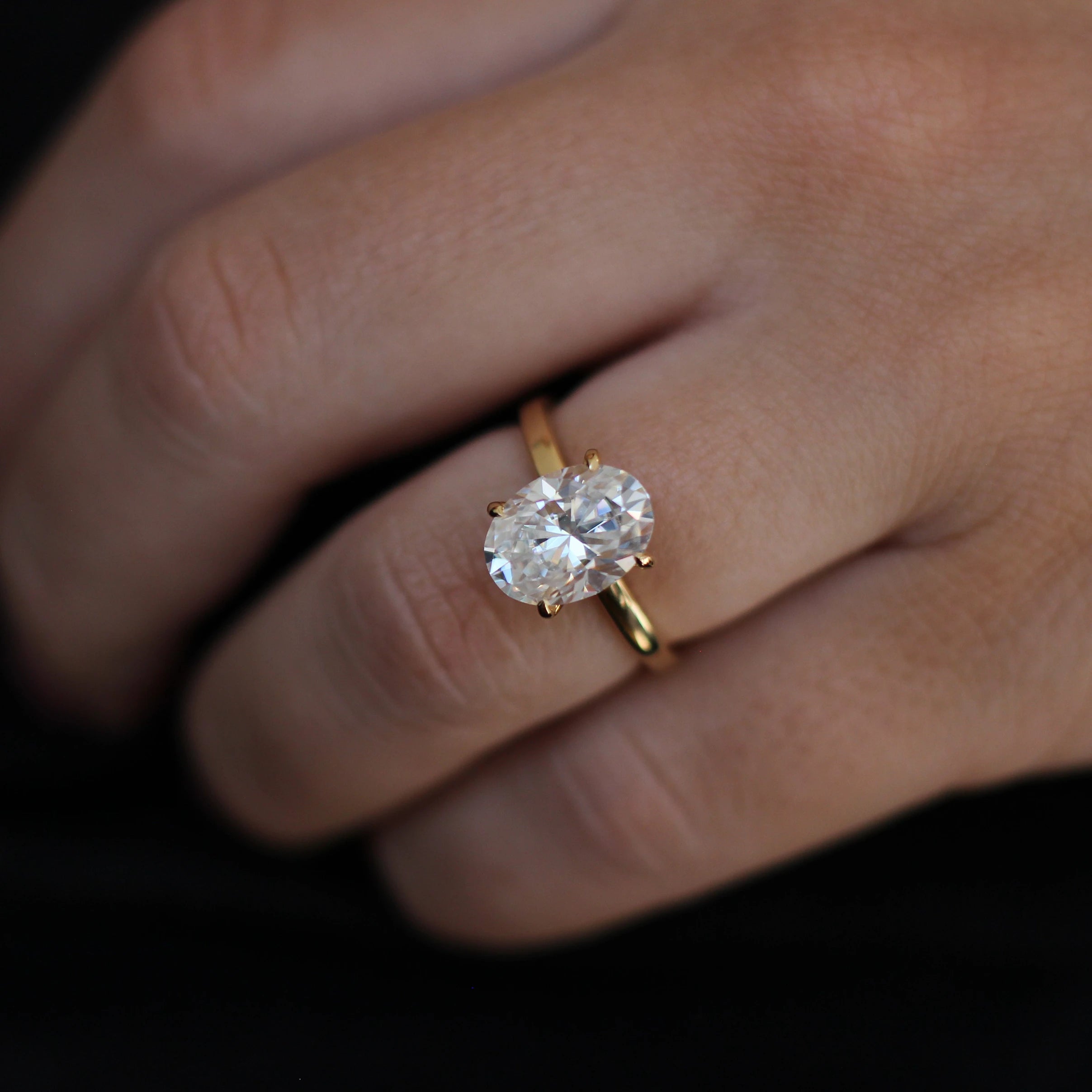 14k gold filled oval ring on model hand against black background