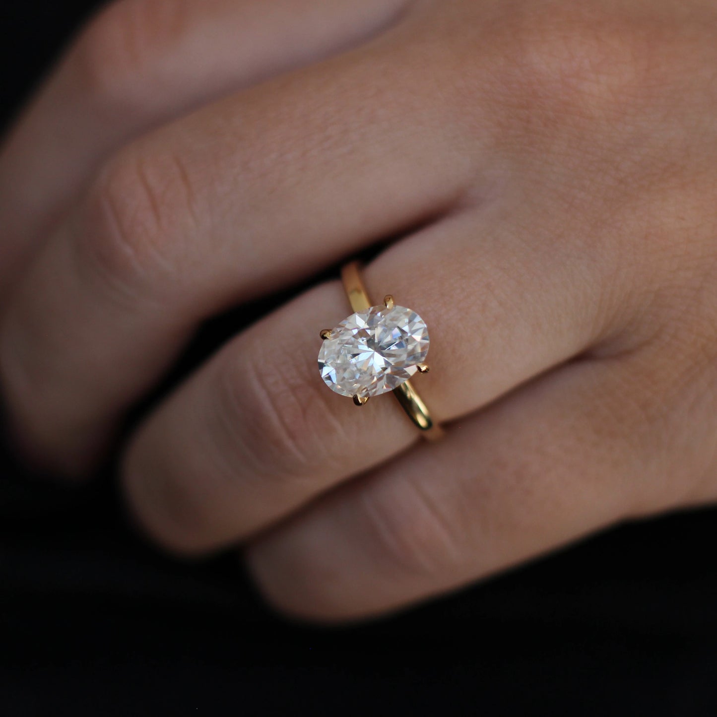 14k gold filled oval ring on model hand against black background