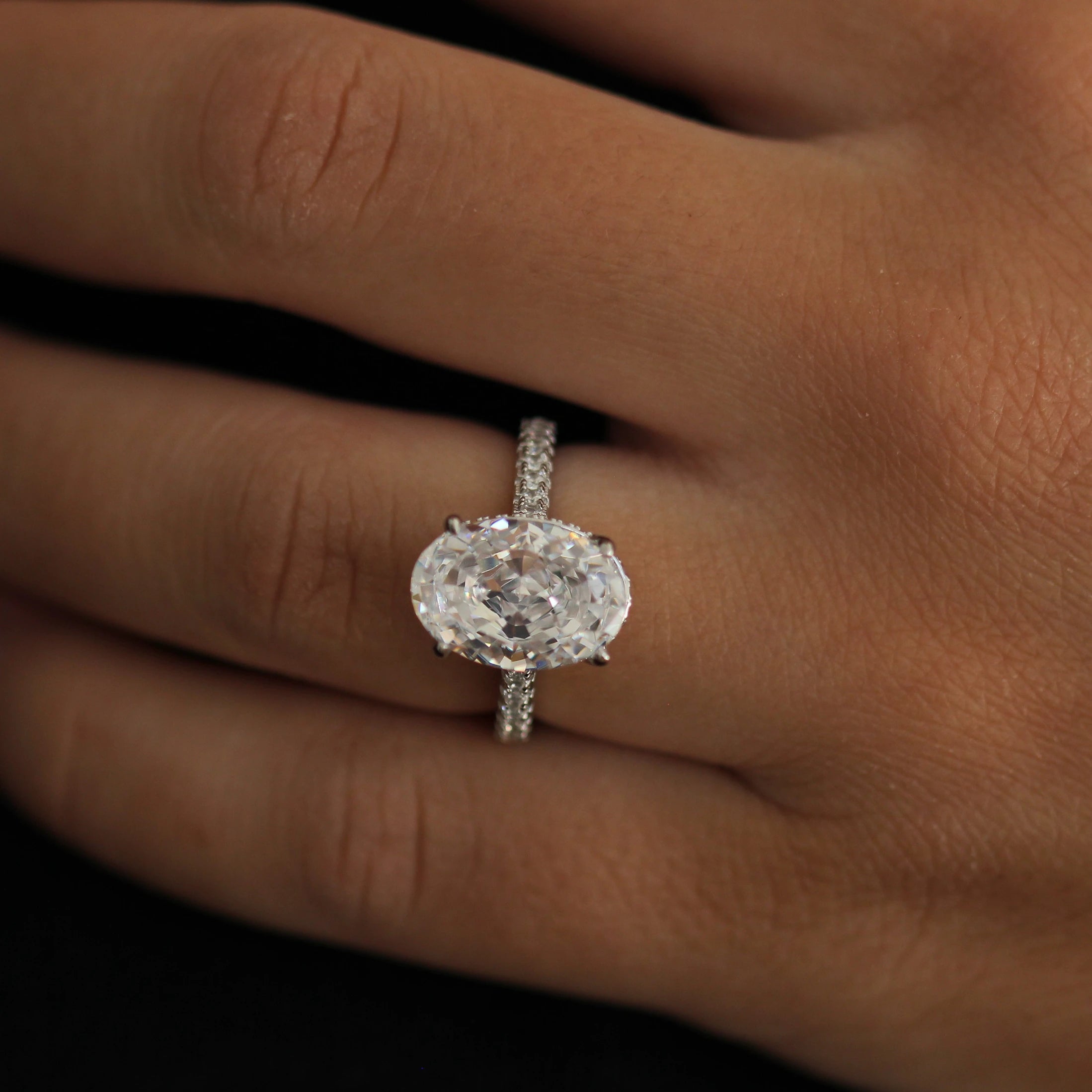 4 carat oval centre stone ring in silver featuring hidden halo and pavé band
