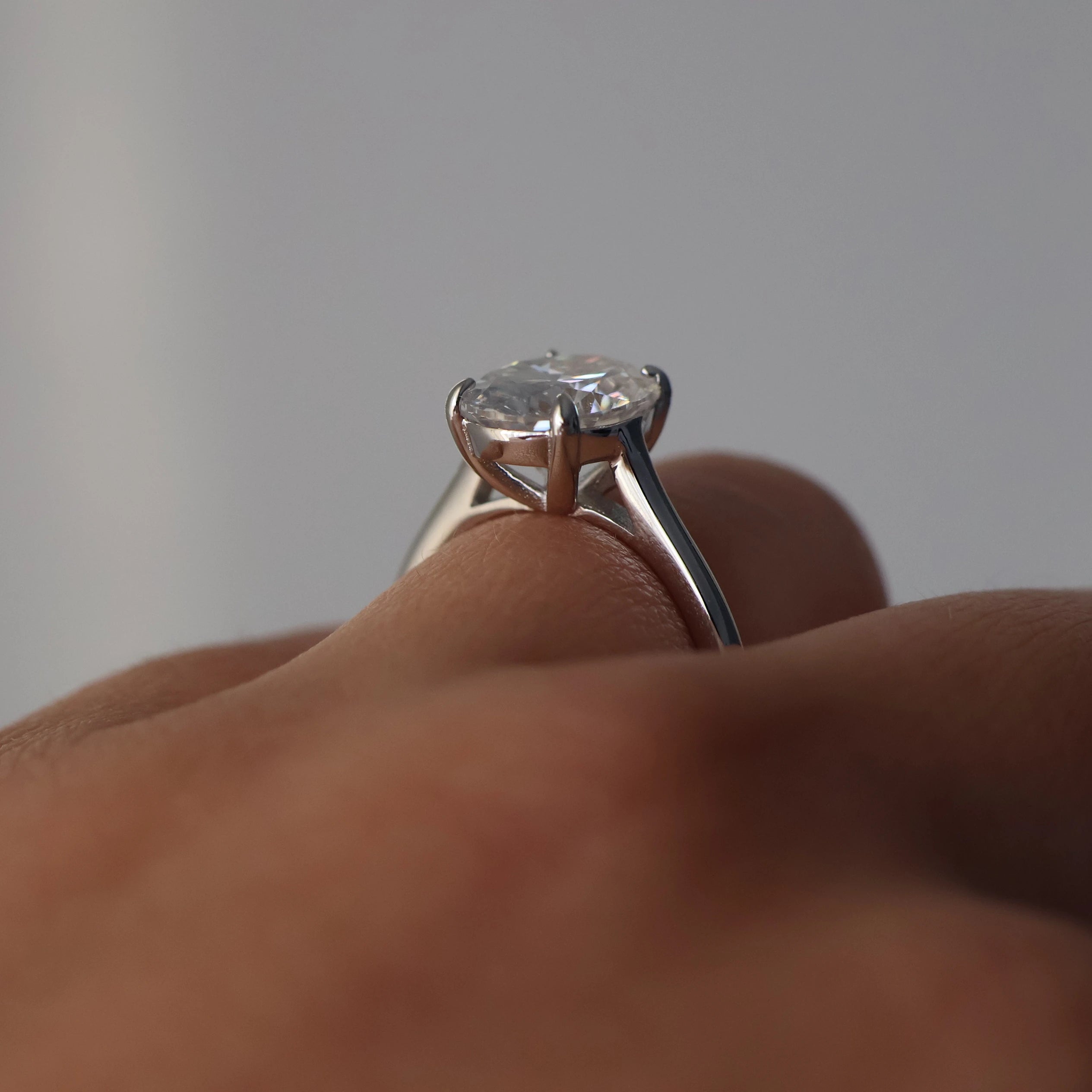 oval moissanite ring on silver band on hand