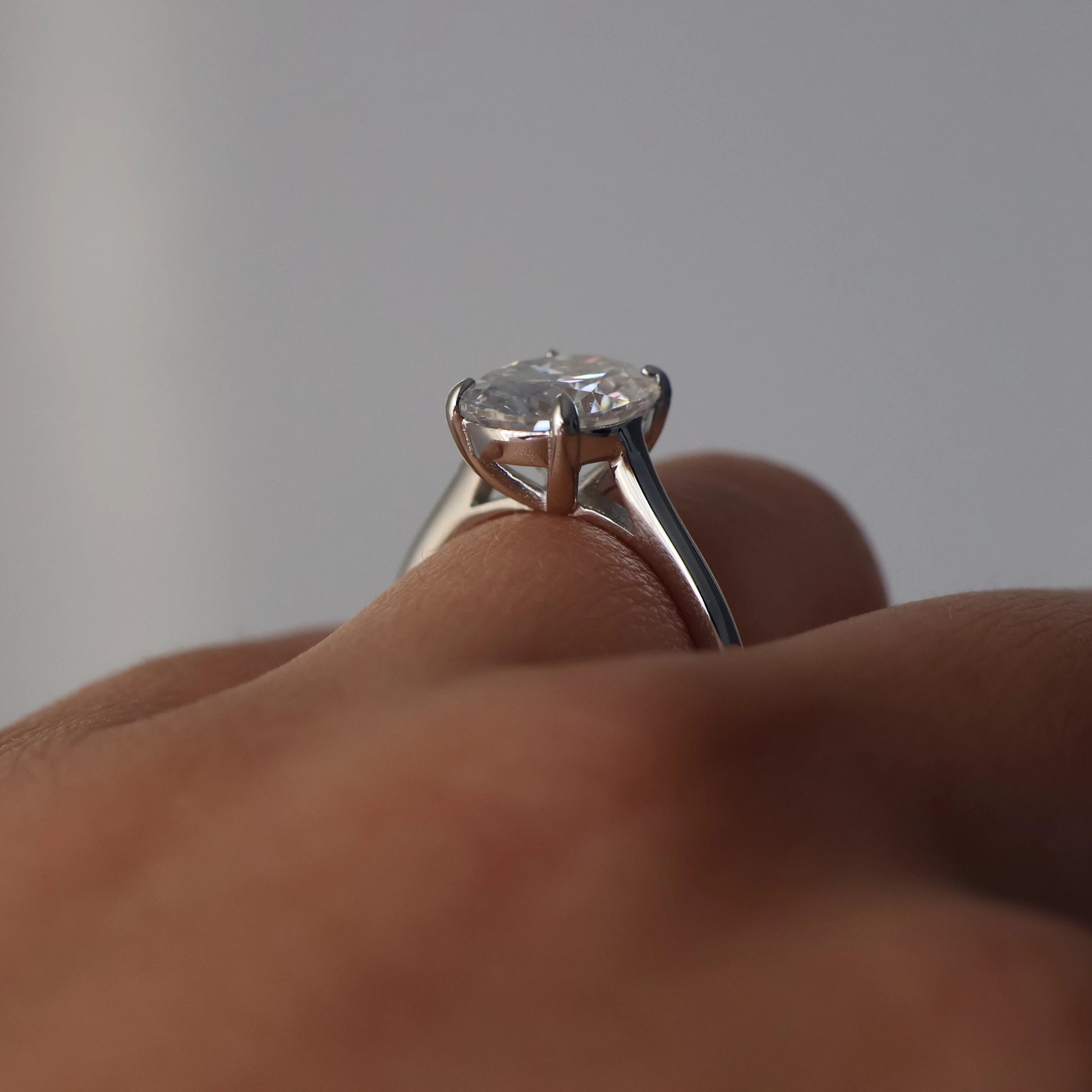 oval moissanite ring on silver band on hand
