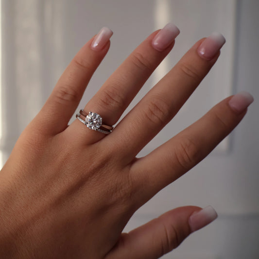 2ct round moissanite ring on hand with pave band
