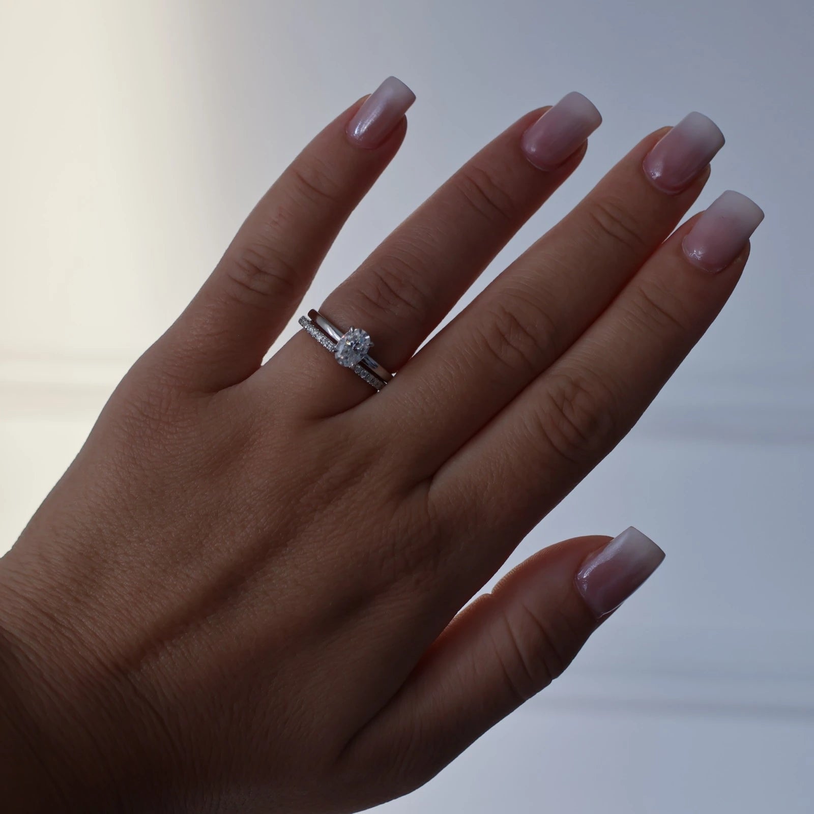 1ct oval moissanite ring on hand stacked with half eternity pavè band