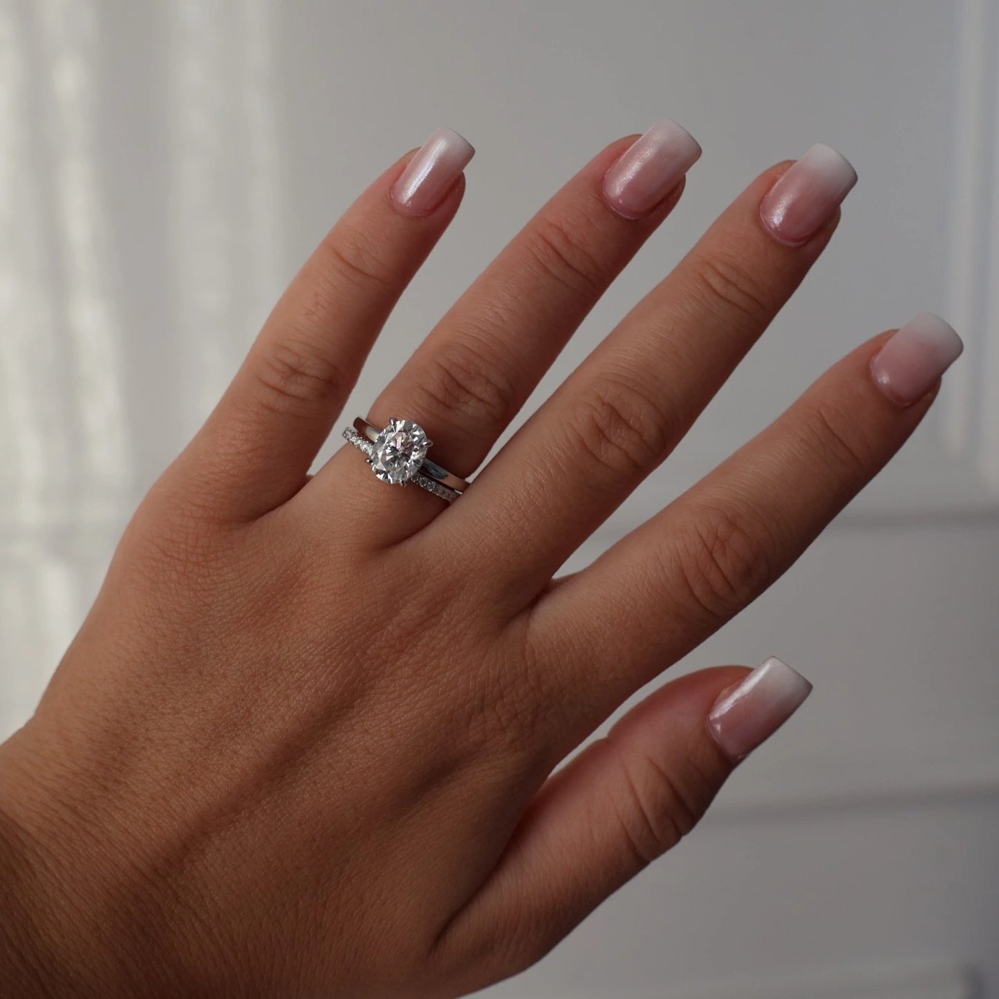 2ct oval moissanite ring on hand stacked with half eternity band