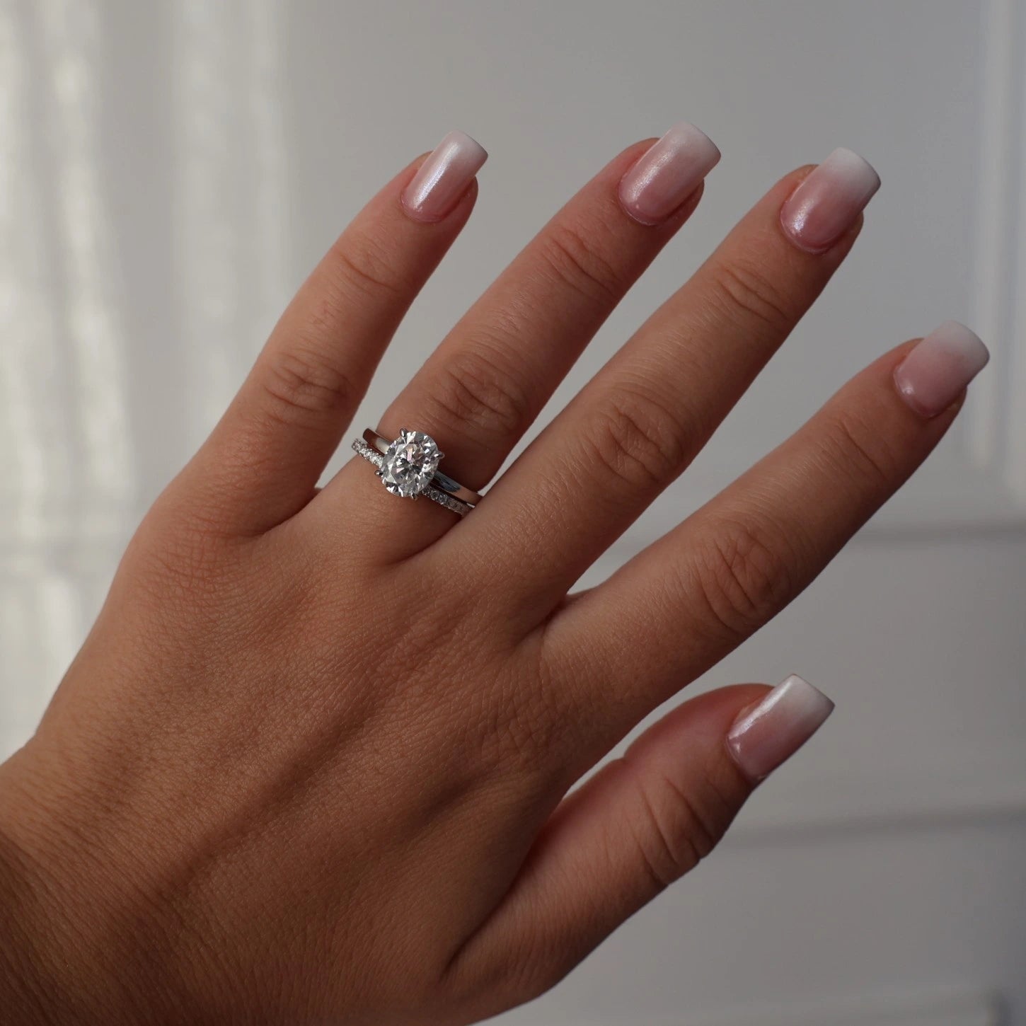 2ct oval moissanite ring on hand stacked with half eternity band