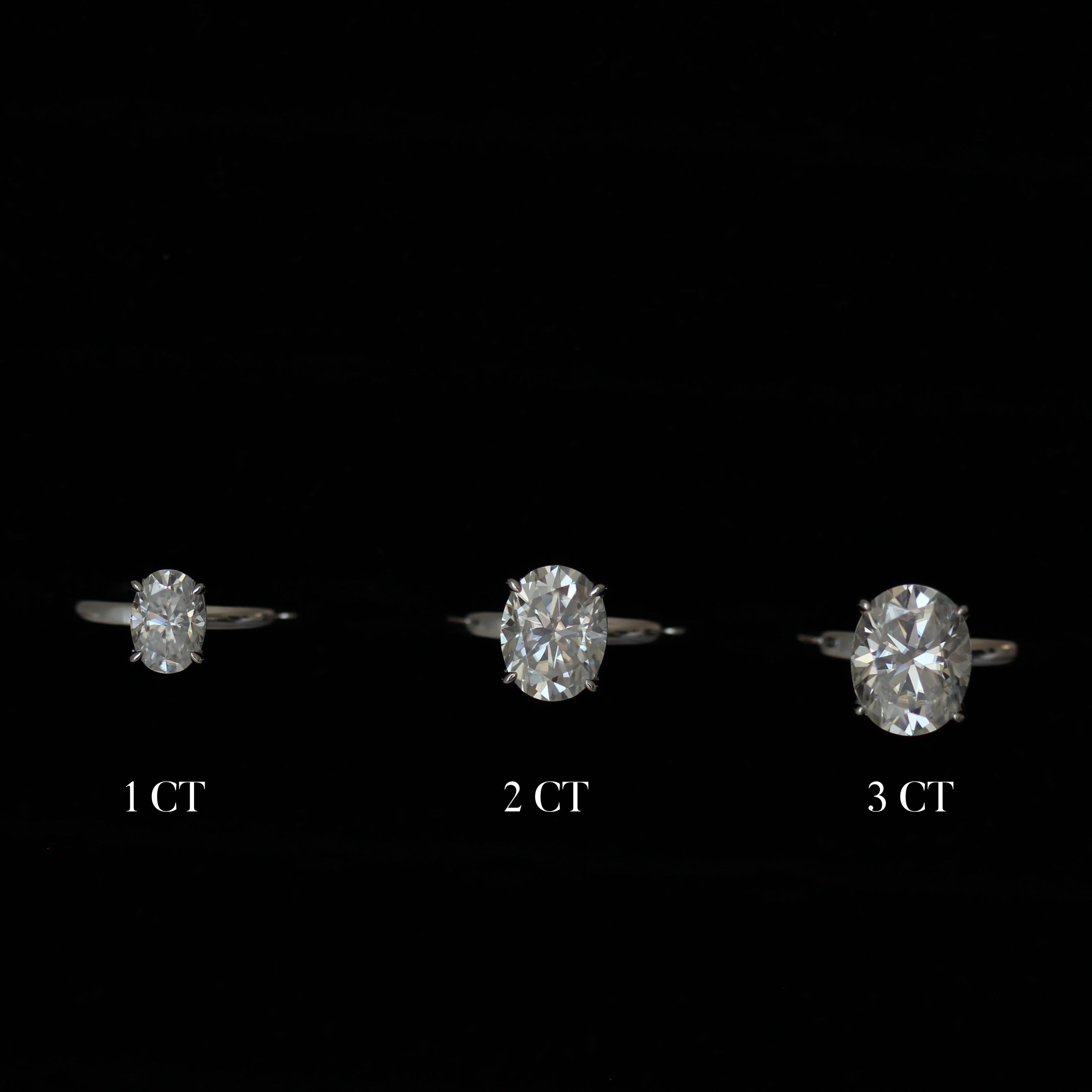 Three moissanite rings with different carat weights on a black background