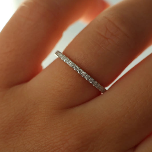 close up of half eternity moissanite pave engagement band on hand