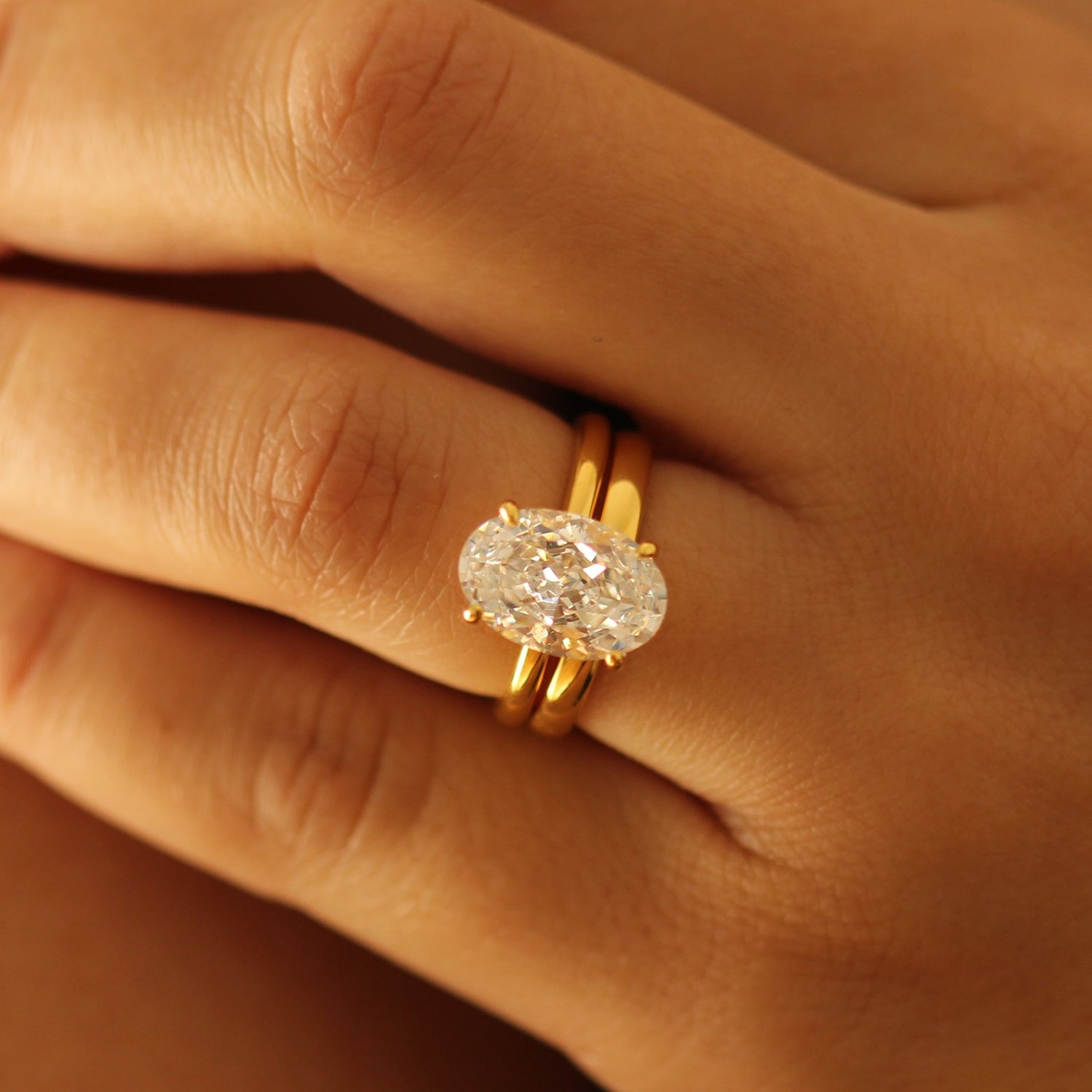 Gold vermeil wedding band and 3.5ct oval ring on hand