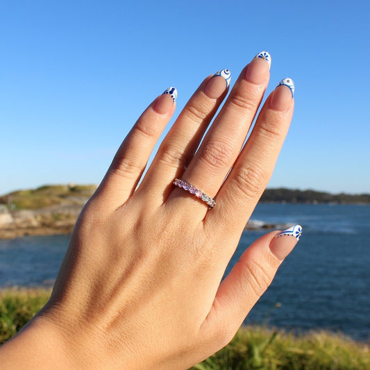 Pink eternity ring in silver on hand at La Perouse Beach, Sydney