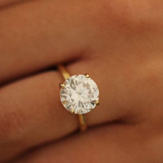 4ct round cut ring on a person's finger