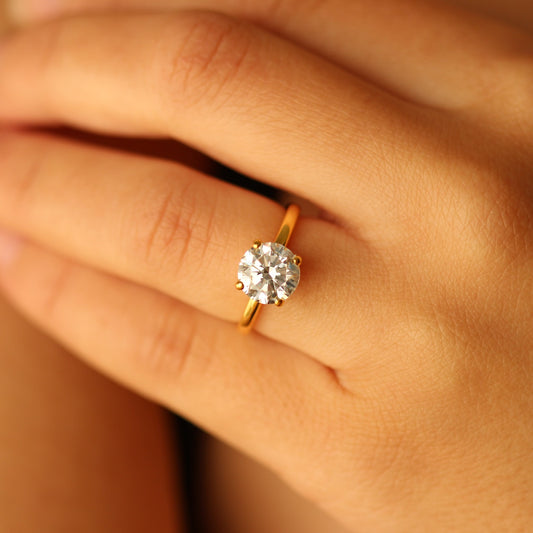 round cubic zirconia gold ring on hand