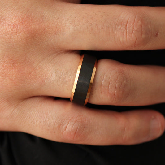 Men’s black wedding band with rose gold beveled edges 