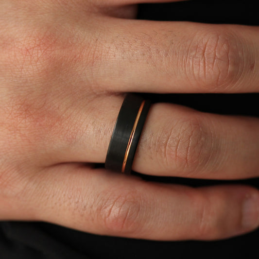 Men’s black wedding ring with rose gold offset line