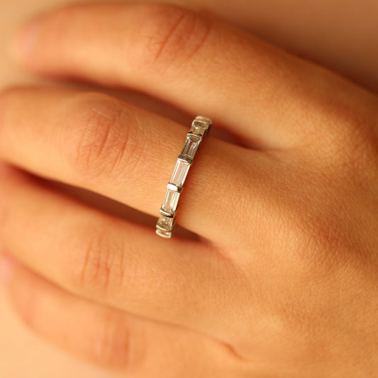 Silver ring with baguette diamonds on a person's finger